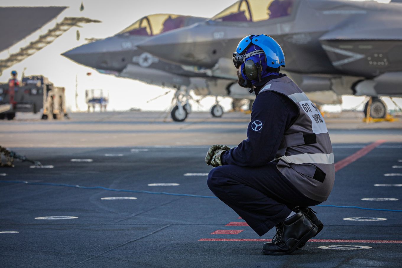 Image shows Royal Navy personnel with F35 aircraft in the background.