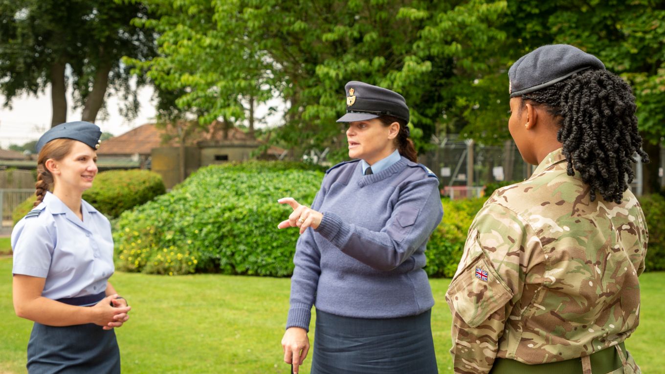 Three female personnel in discussion.