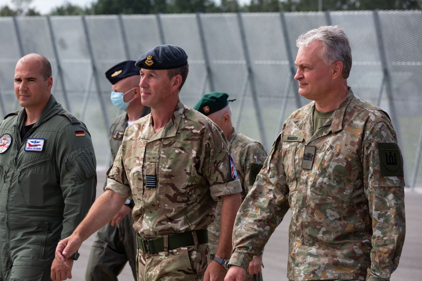 Image shows Gitanas Naus?da, the President of Lithuania, walking with RAF, German Air Force and Spanish Air Force personnel.
