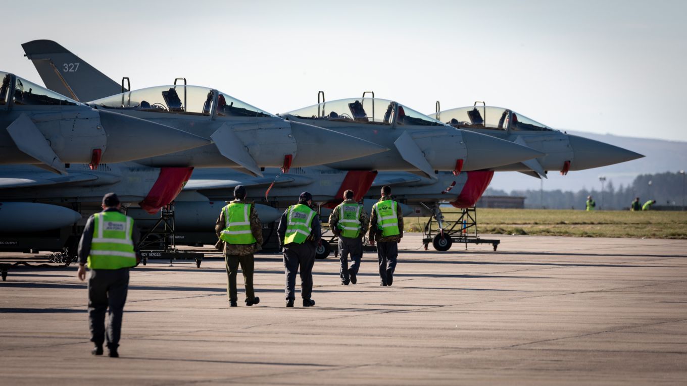 Image shows RAF ground crew walking towards the RAF Typhoons after landing.