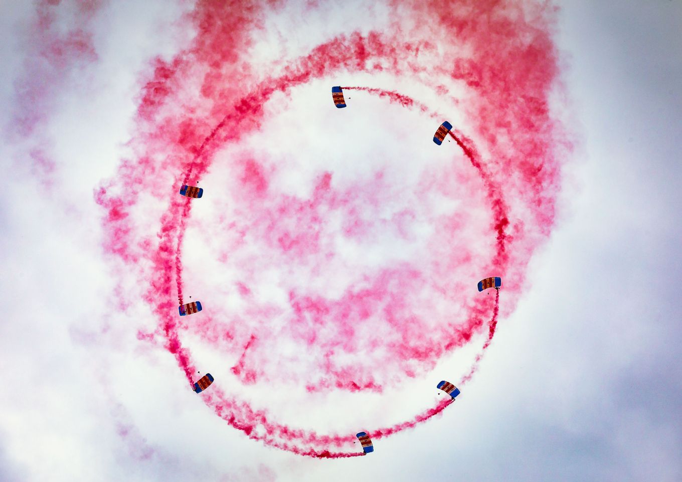 Parachuting Display Team performing above, with red smoke trails.