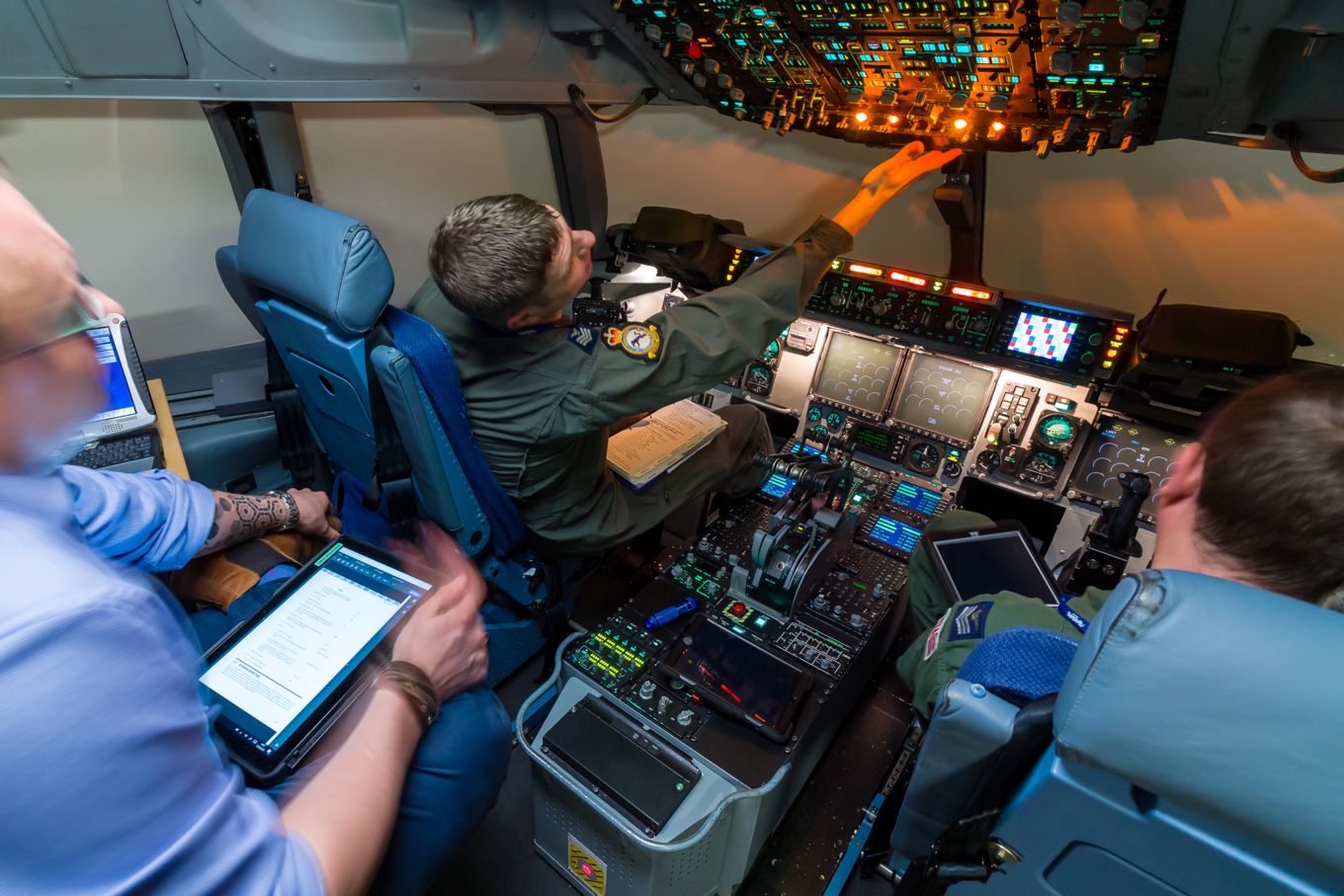 Three personnel train in a Boeing International Training Facility flight simulator cockpit. 