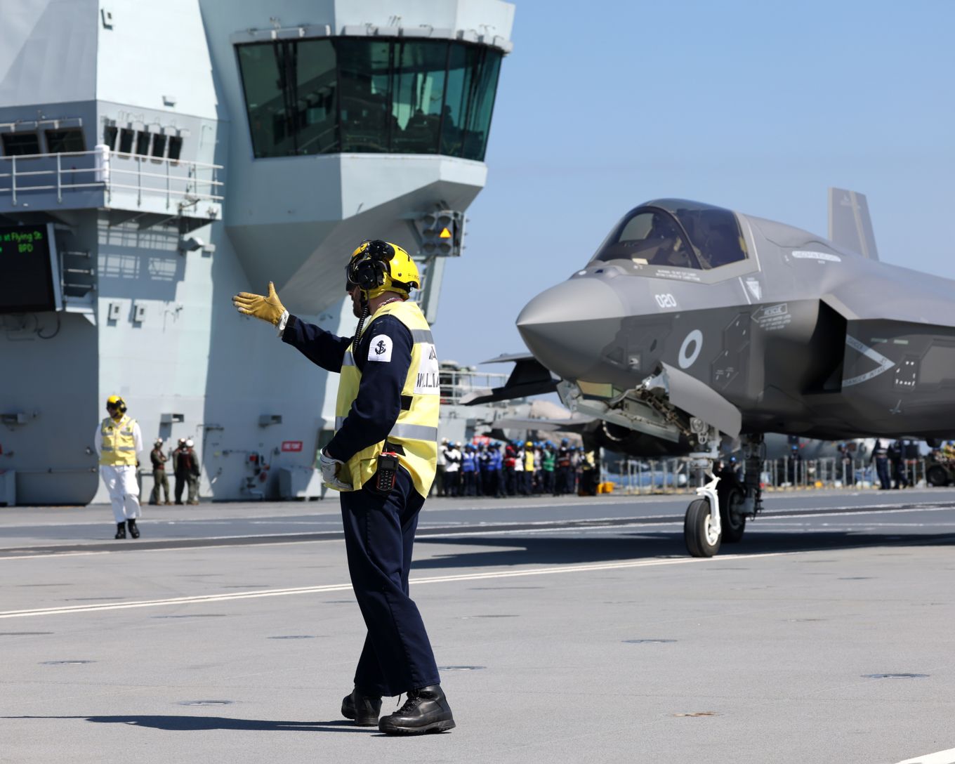 Man wearing hi-vis with Fighter jets landing in the background