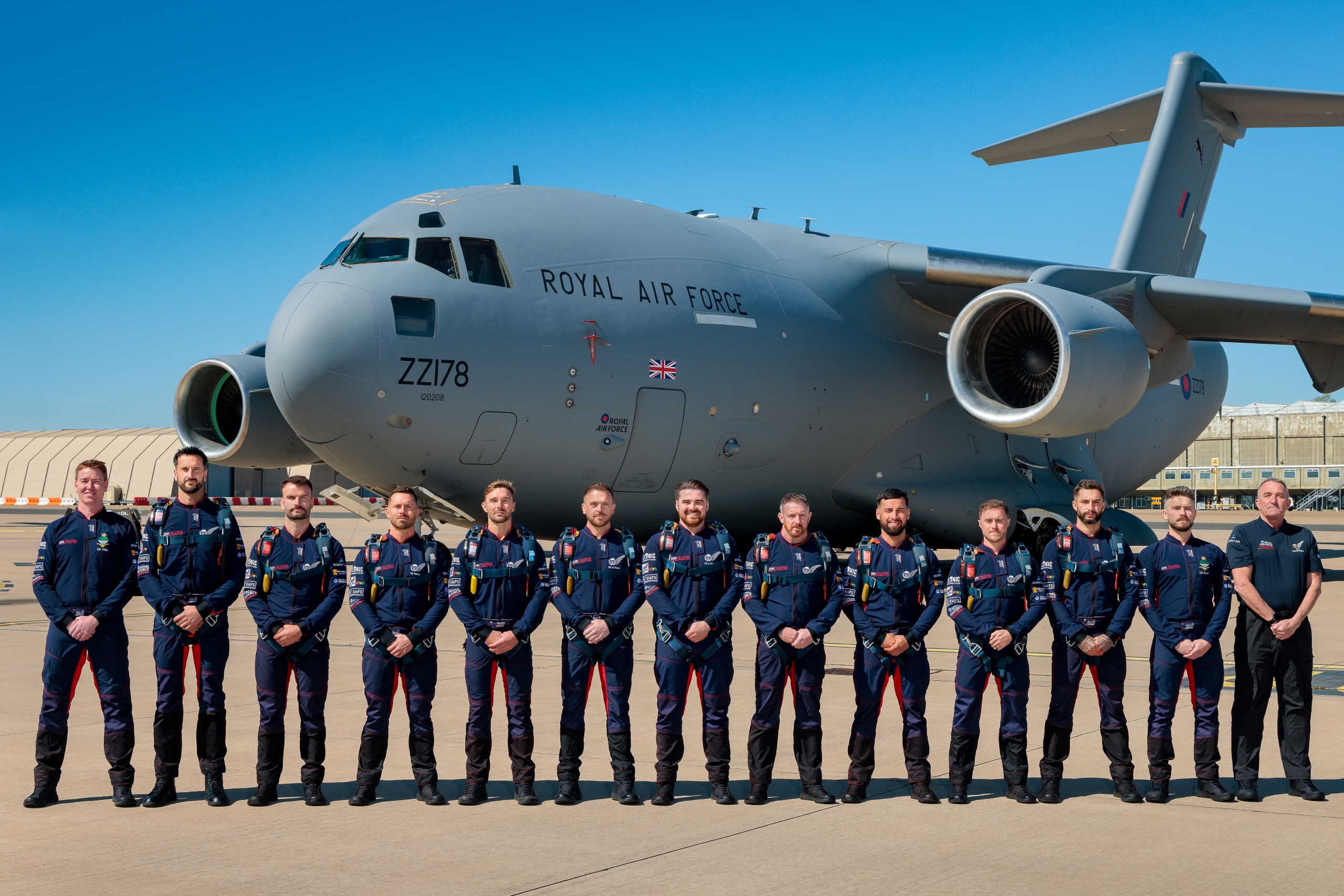 Decoration - Photo of the 2026 RAF Falcons Parachute Display Team standing as a team in front of a Royal Air Force Globemaster (C-17A) aircraft.