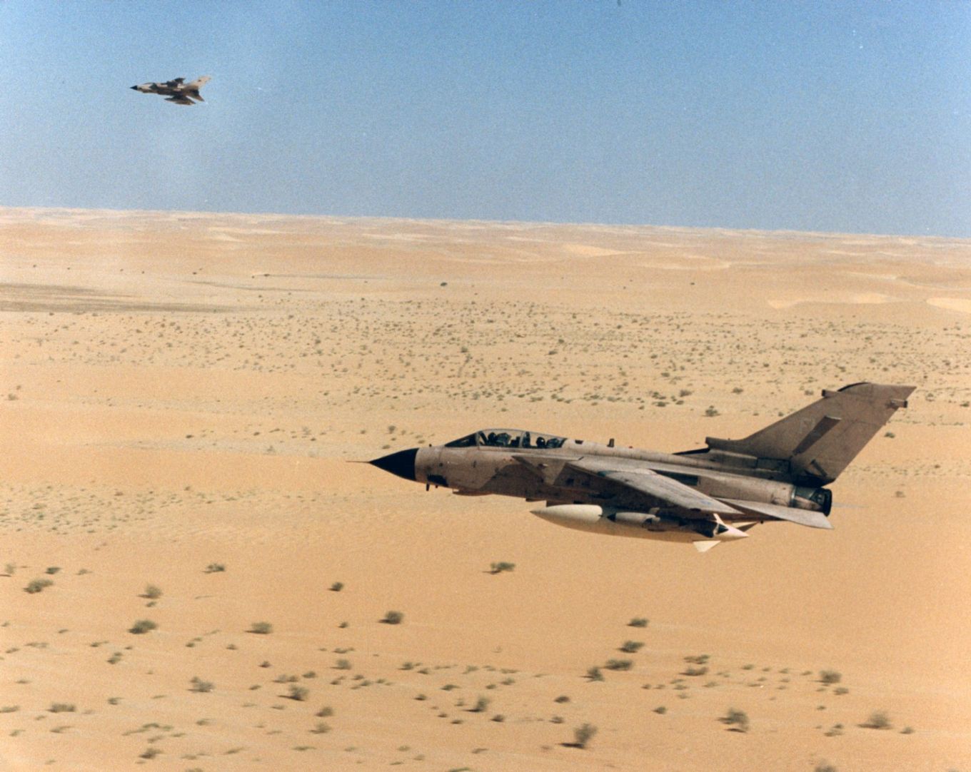 Image shows an RAF Tornado flying above a sandy desert.