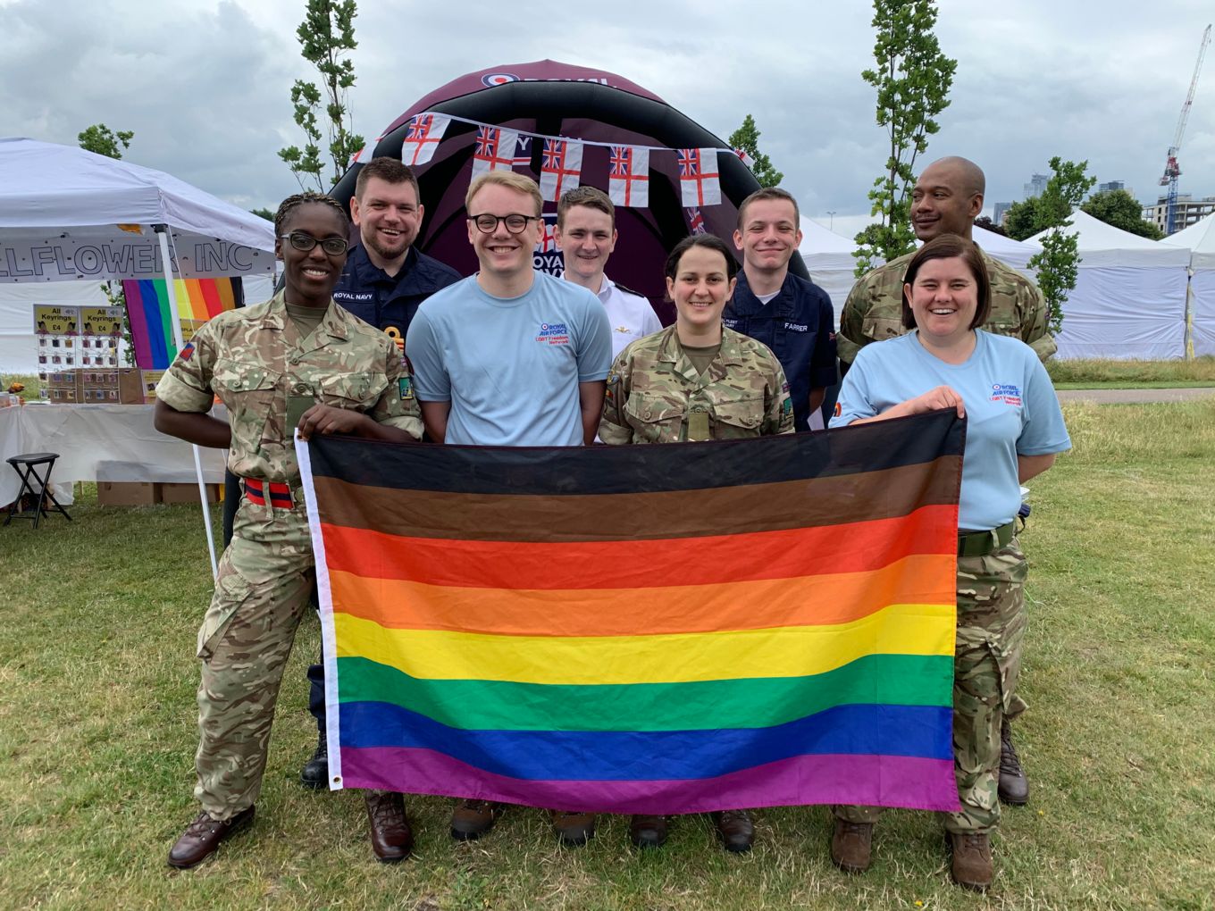 Personnel stand with the pride flag.