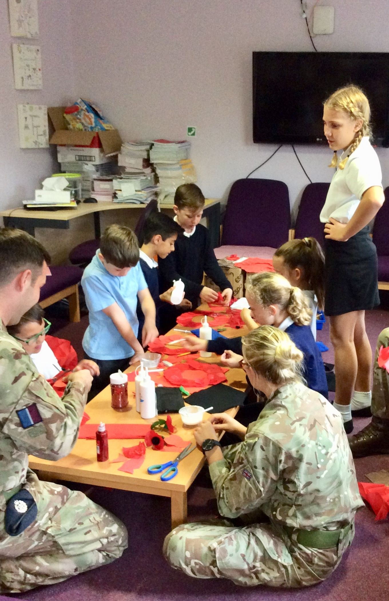 The team from 2MT help pupils make their remembrance wreaths.