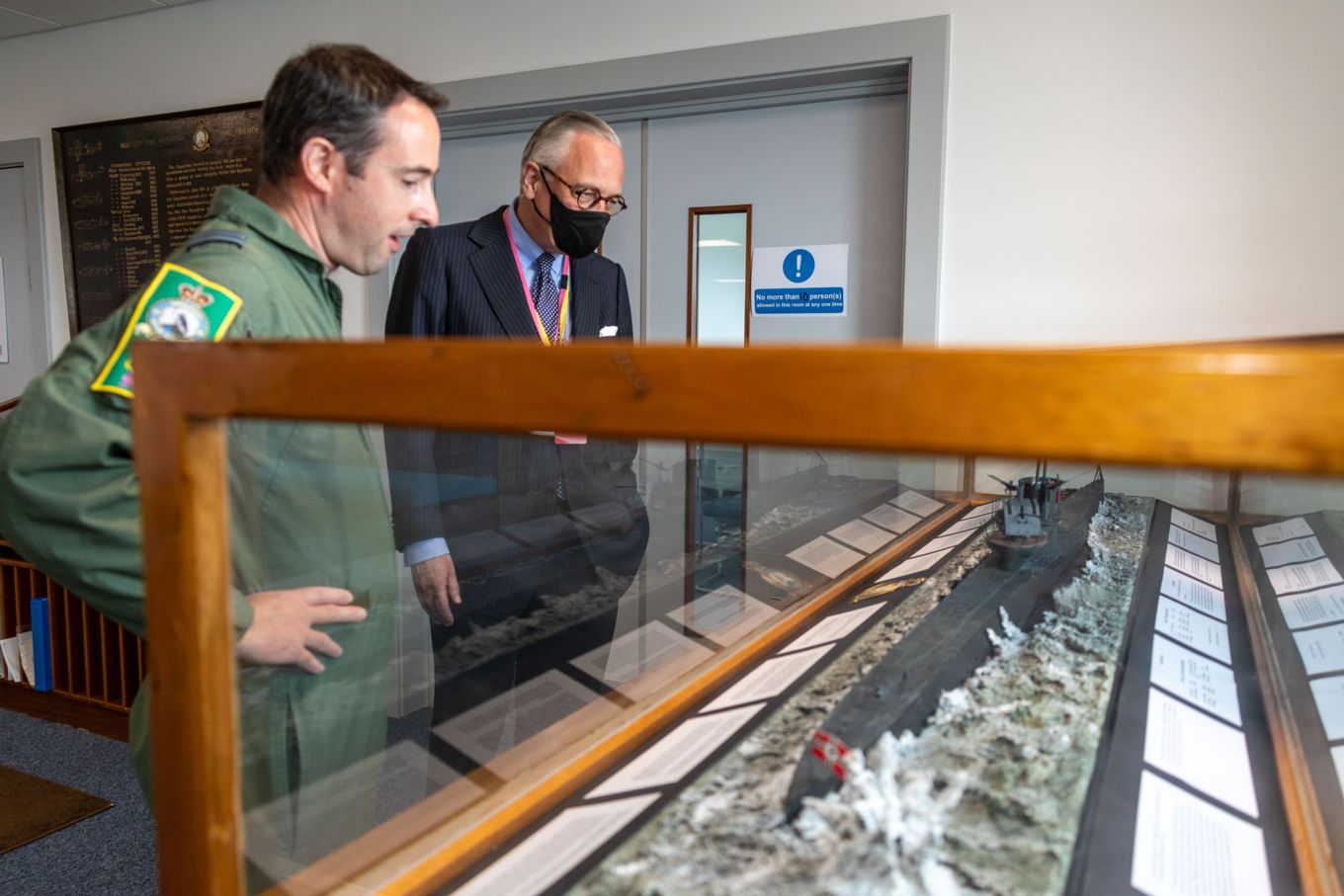 Group Captain Layden and His Excellency Mr Sturla Sigurjónsson look at a destroyer model.