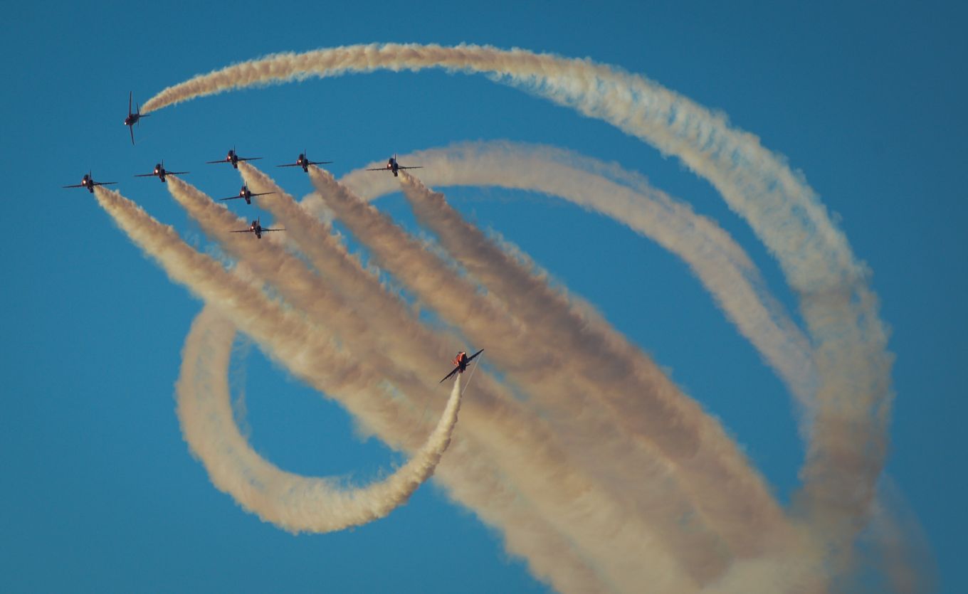 Red Arrows in formation with smoke trails.