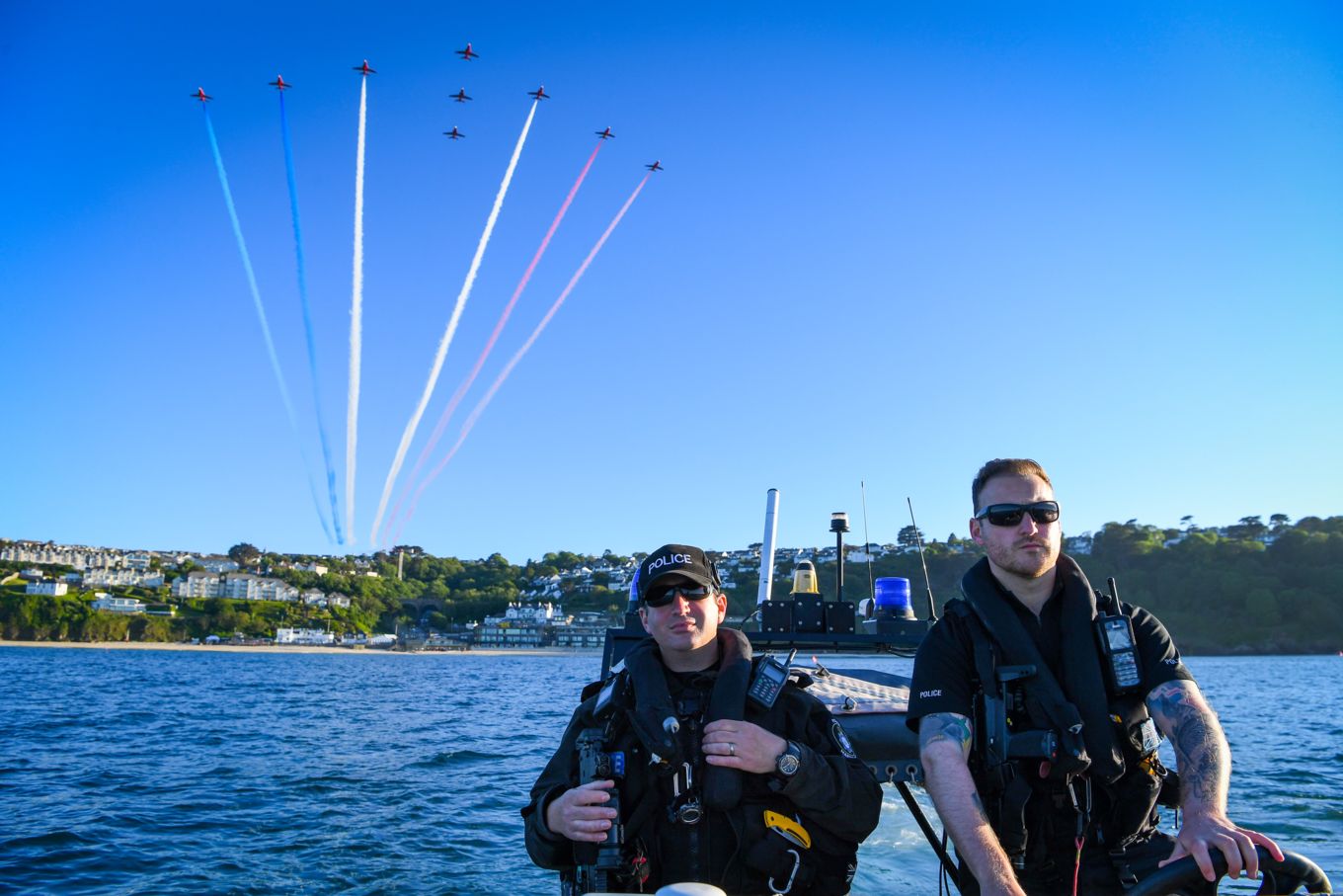 Red Arrows in formation with RAF Police personnel on the river. 