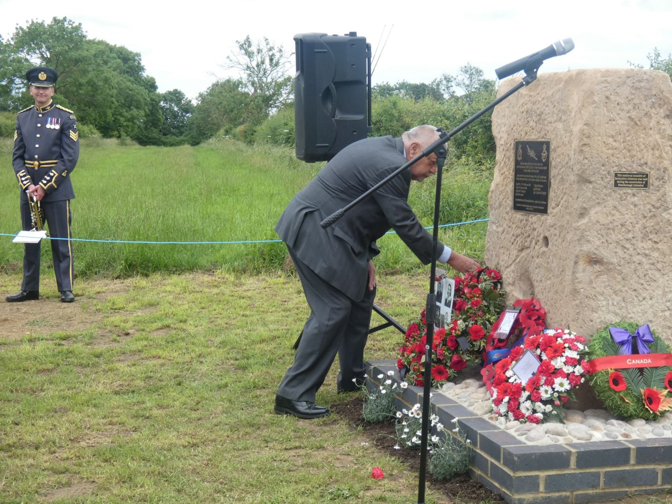 Mr Lindsay Alvis laying a wreath at the memorial. Microphone and speakers in shot too. 