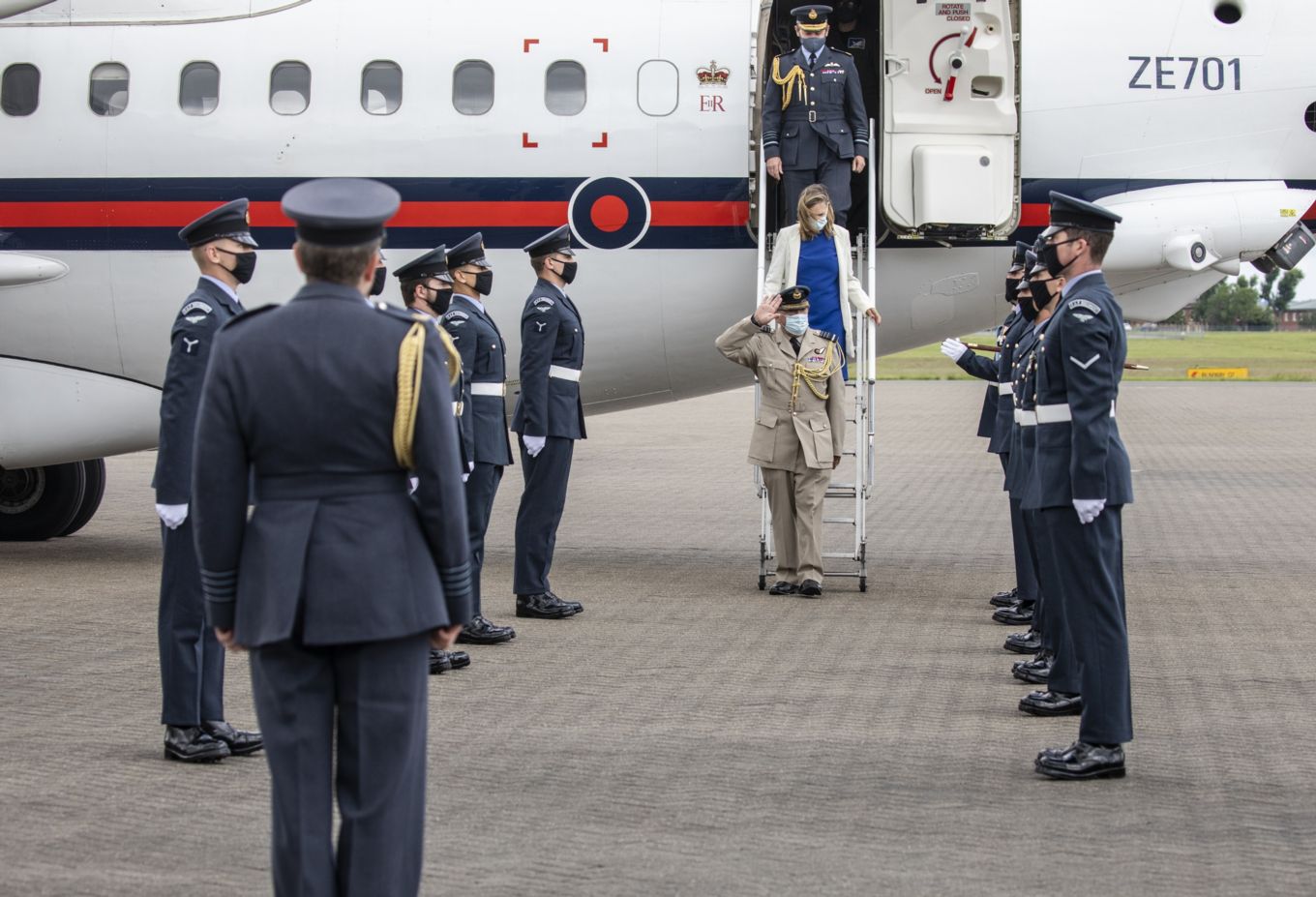 Air Chief Marshal Sir Stuart Peach saluting the gathered personnel as he leaves transport Aircraft.