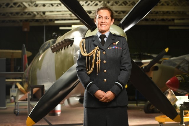 Air Commodore Suraya Marshall stands in-front of a Spitfire.