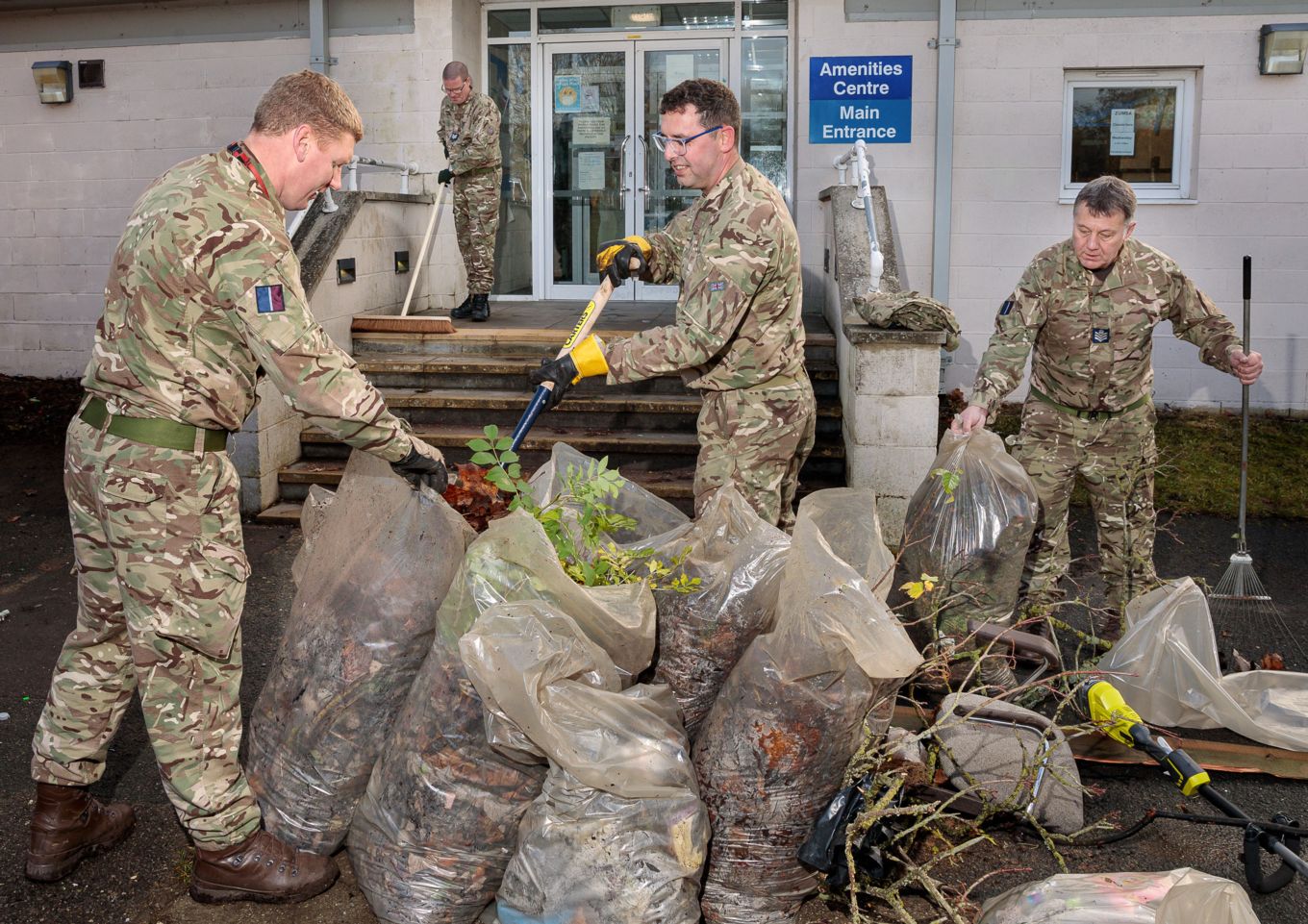 Flight Sergeant Hull, Sergeant Bannerman, Sergeant Walker and Sergeant Rogers tidying up and collecting rubbish from the surrounding areas of the MAC