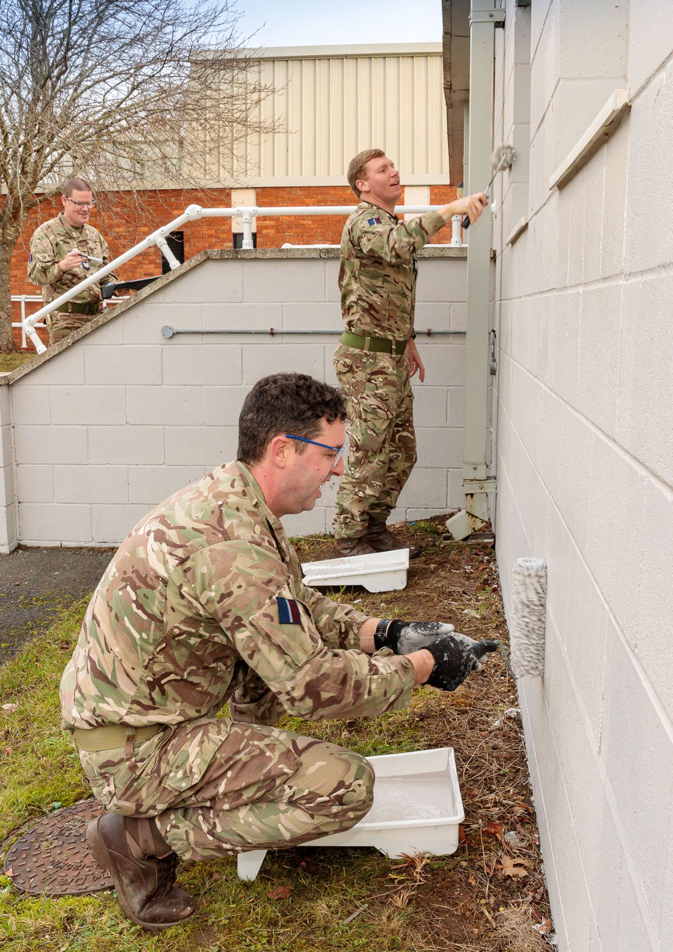Sergeant Rogers, Sergeant Bannerman and Sergeant Walker painting the outside of the building.