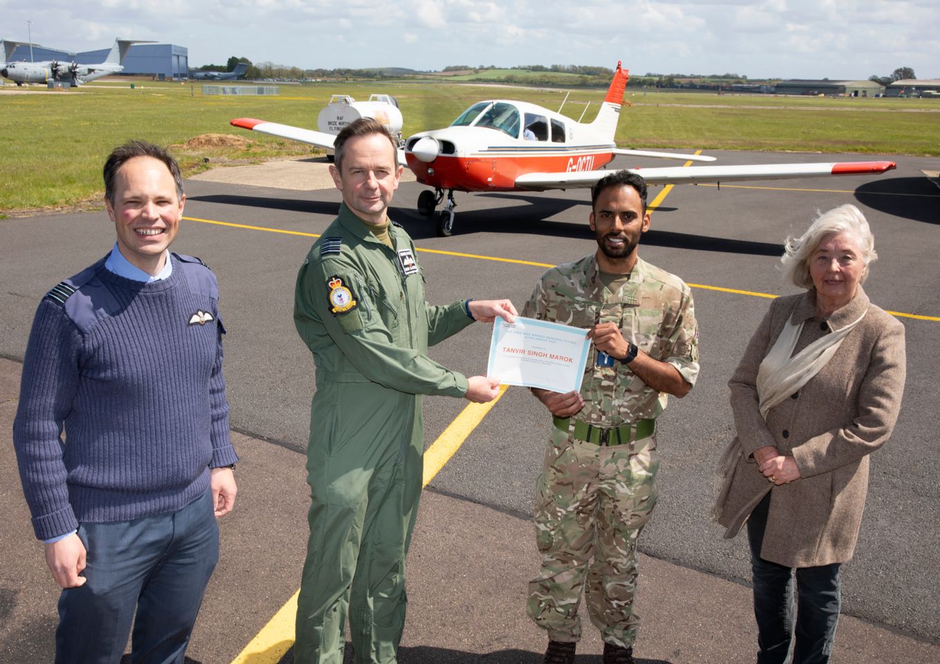 Group Captain Simon Blackwell presents the certificate to Senior Aircraftman Tavi Marok with Alison Barnes and Wing Commander James Sjoberg present