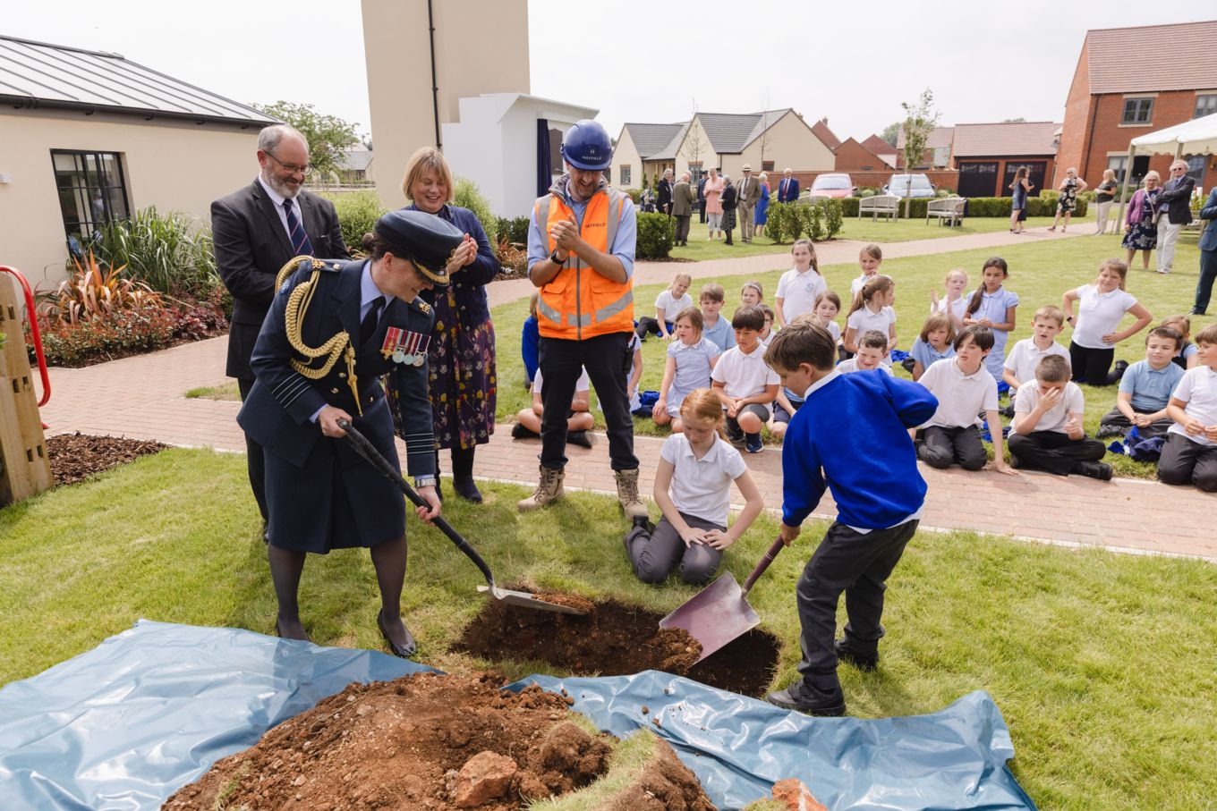 Group Captain Emily Flynn burying the time capsule with children from Stanton Harcourt Primary School