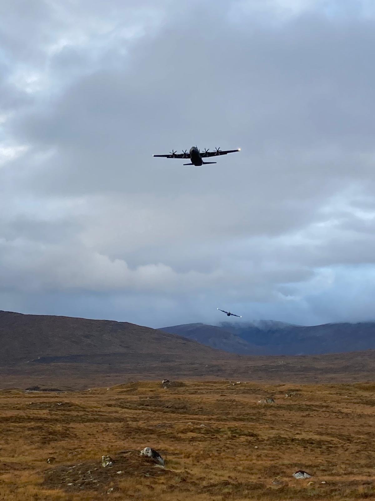 As part of Exercise Tartan Spirit, two C-130J Hercules conduct formation flying training through the mountainous terrain