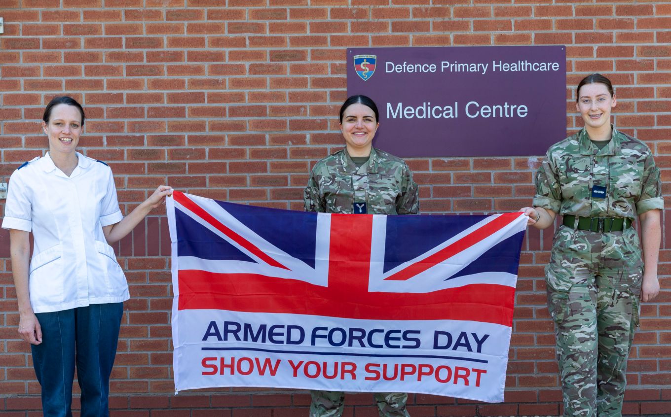 Health Care Professionals holding the Armed Forces Day Flag