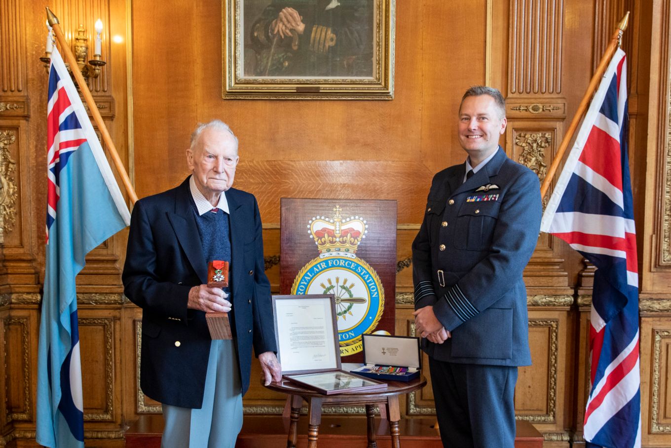 Image shows an RAF Officer with an elderly veteran standing next to each other..