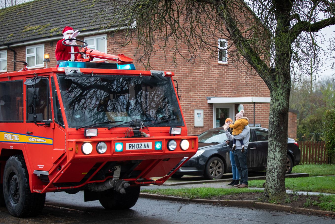 Santa on a fire engine waving to children