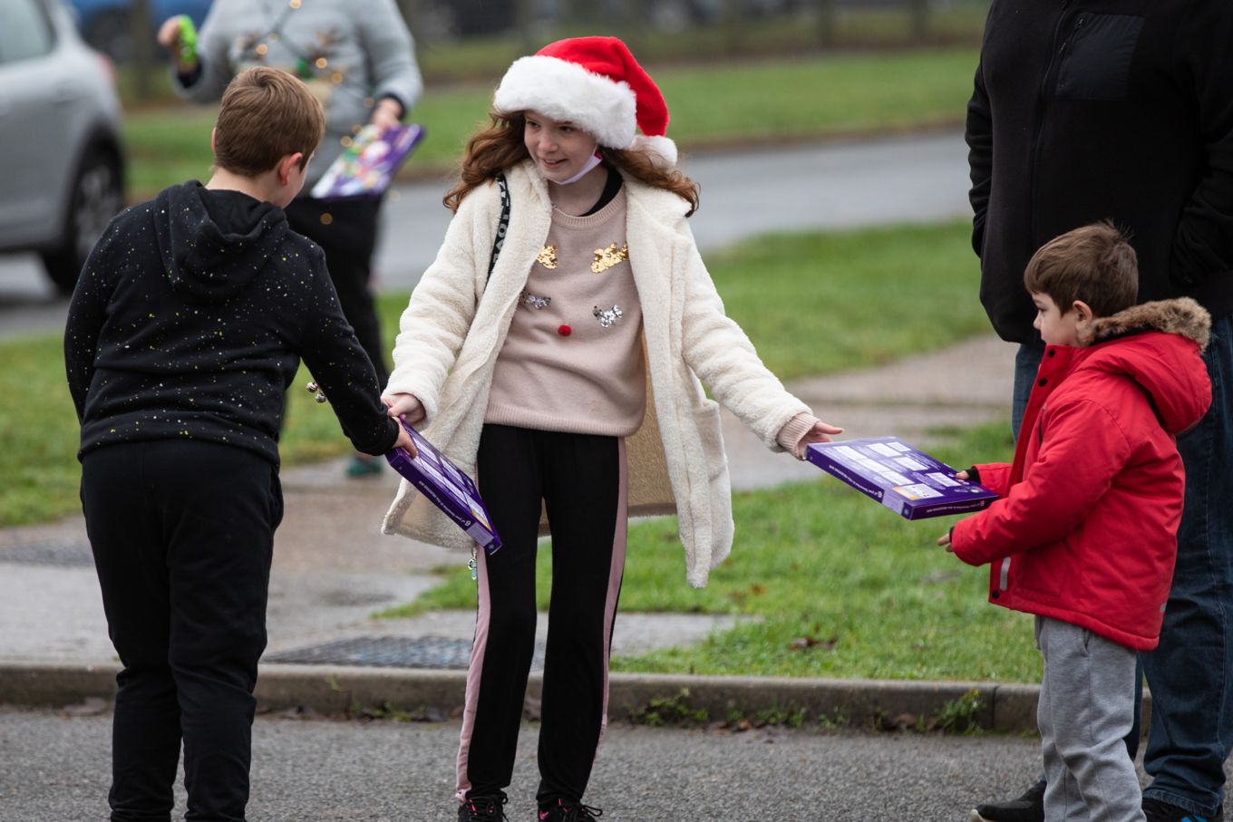 Santa's helper handing out selection box to children