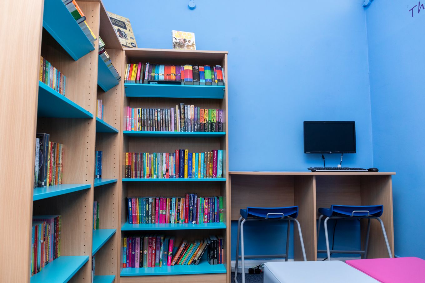 A view of a computer and bookshelves within the library