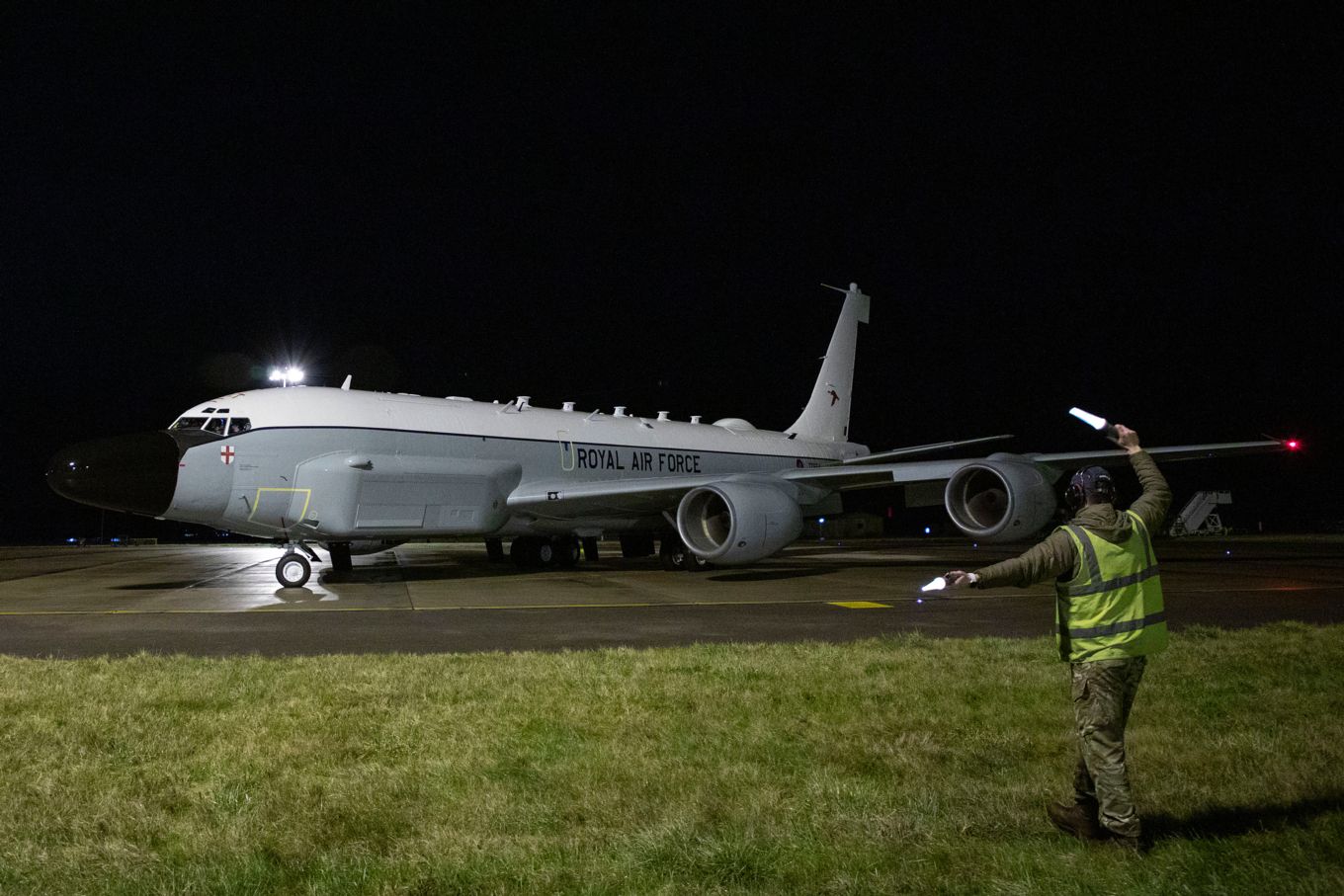 Image shows an RAF Rivet Joint aircraft on the ground at night.