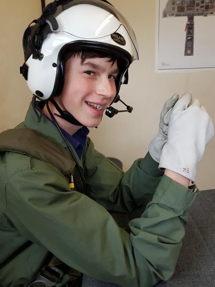 Aleksander smiling with aviation kit and helmet on. 