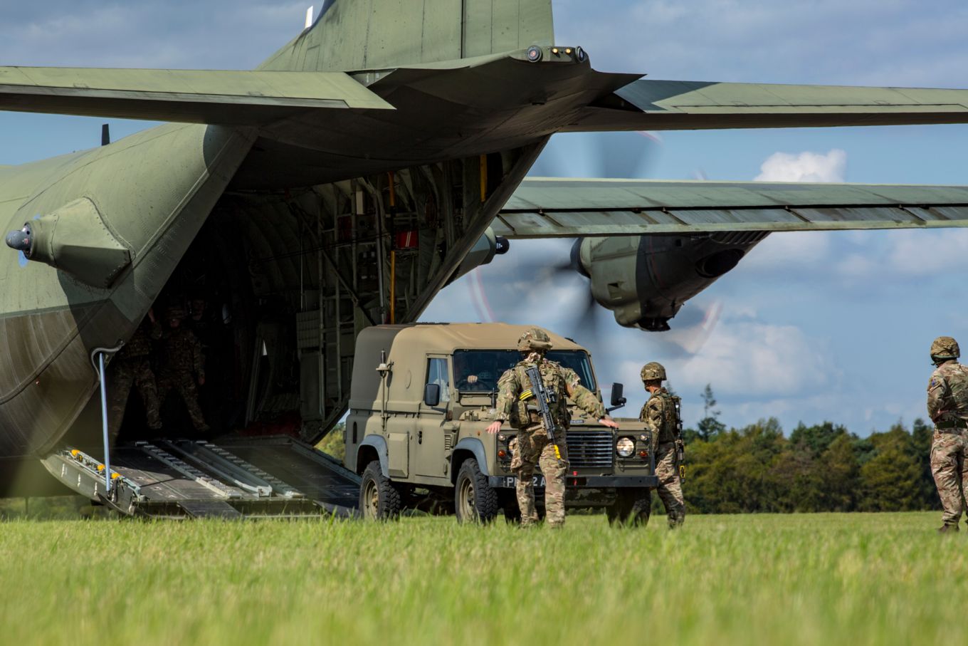 1AMW personnel loading a military vehicle onto an RAF Hercules