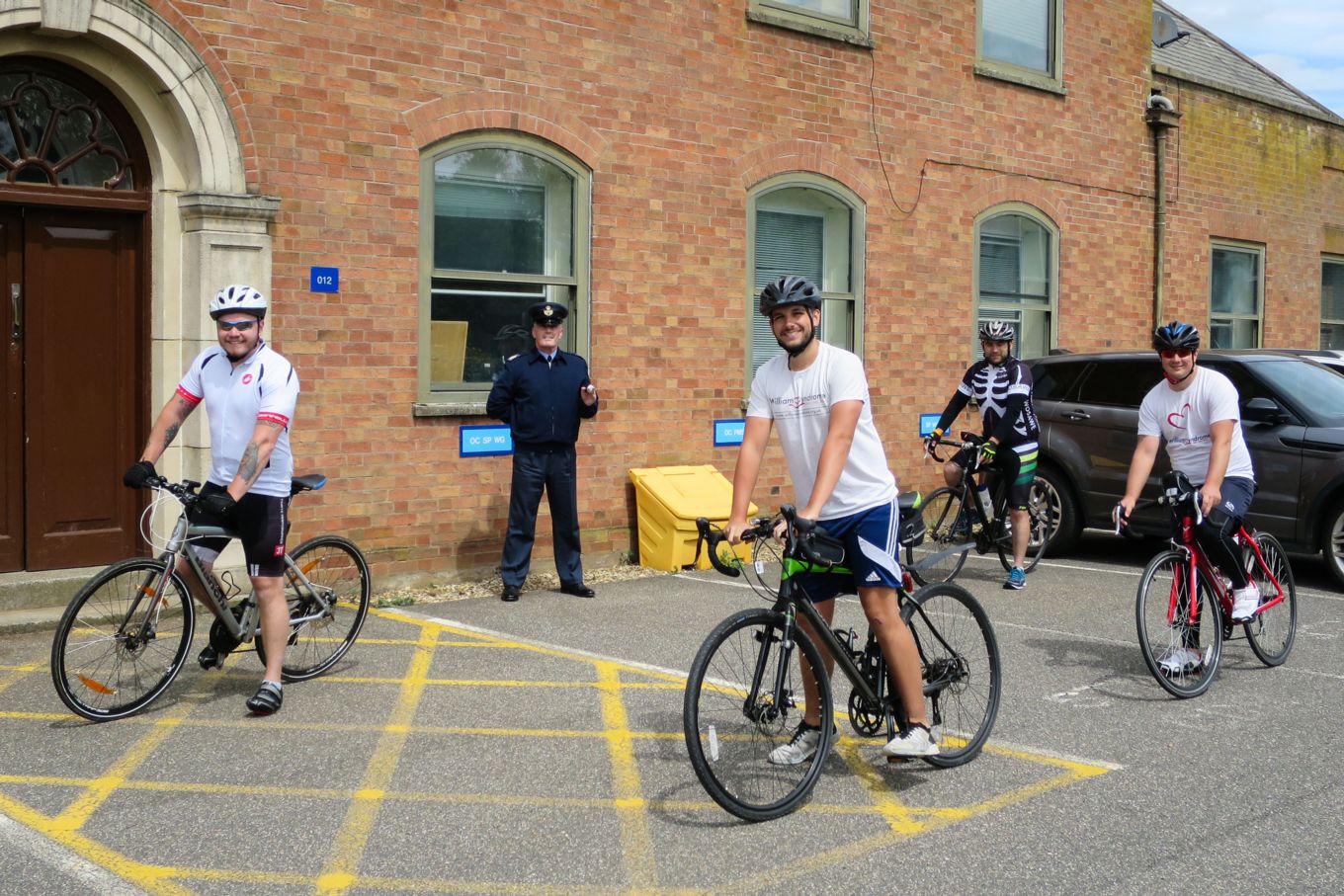 The No 3 Mobile Catering Squadron riders finish the challenge at the Station Warrant Officer's office. SAC Rob Dowie is front and centre. WO Greening stands at the rear