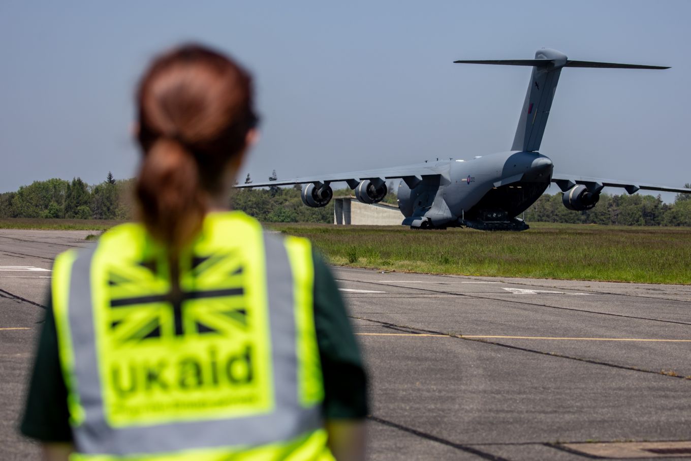 A member of the FCDO Humanitarian Stabilisation & Operations Team looks on.