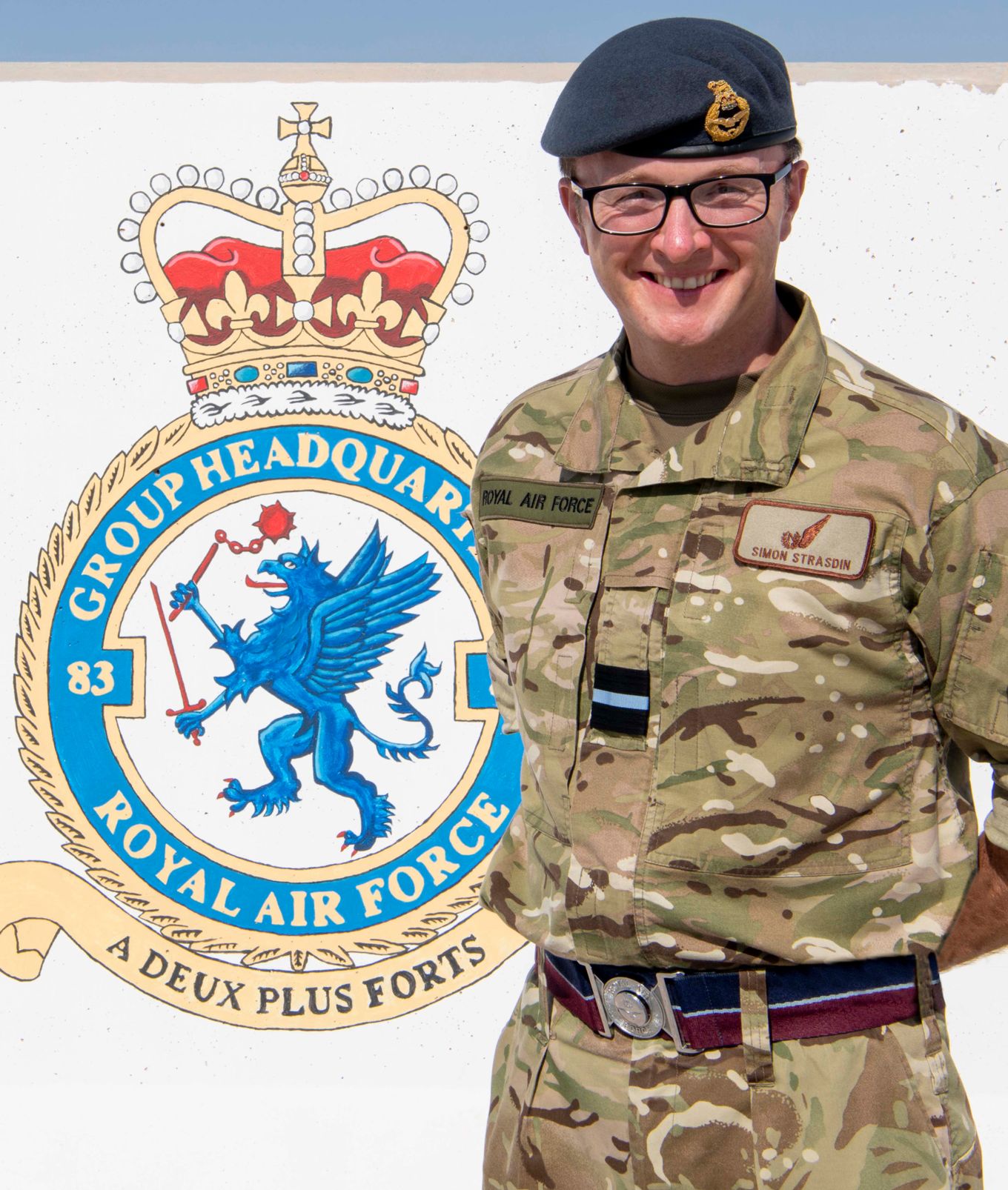 Personnel stands with badge of 83 Expeditionary Air Group.