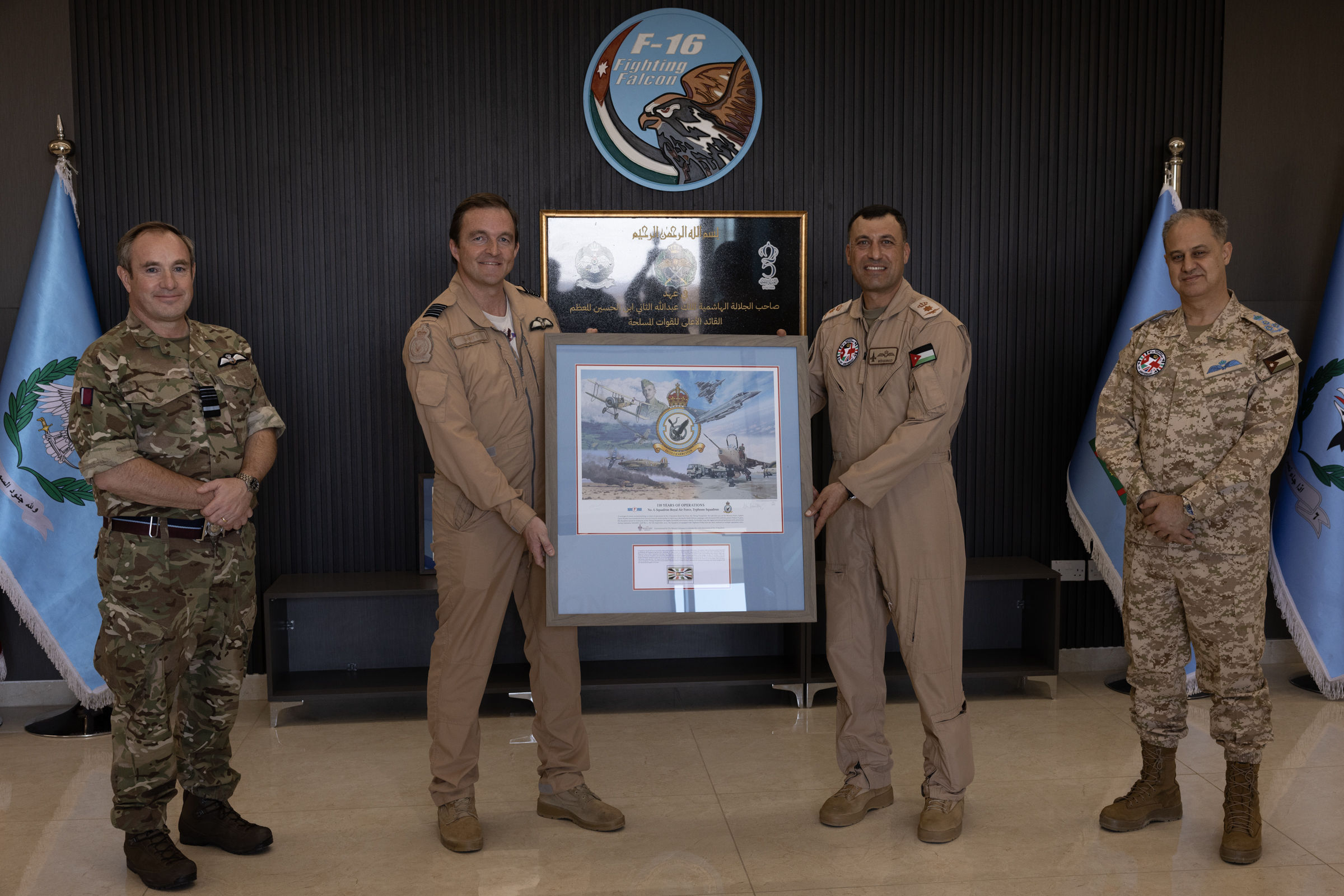 Officers from the RAF and RJAF holding a commemorative plaque to honour the 75th year of their partnership.