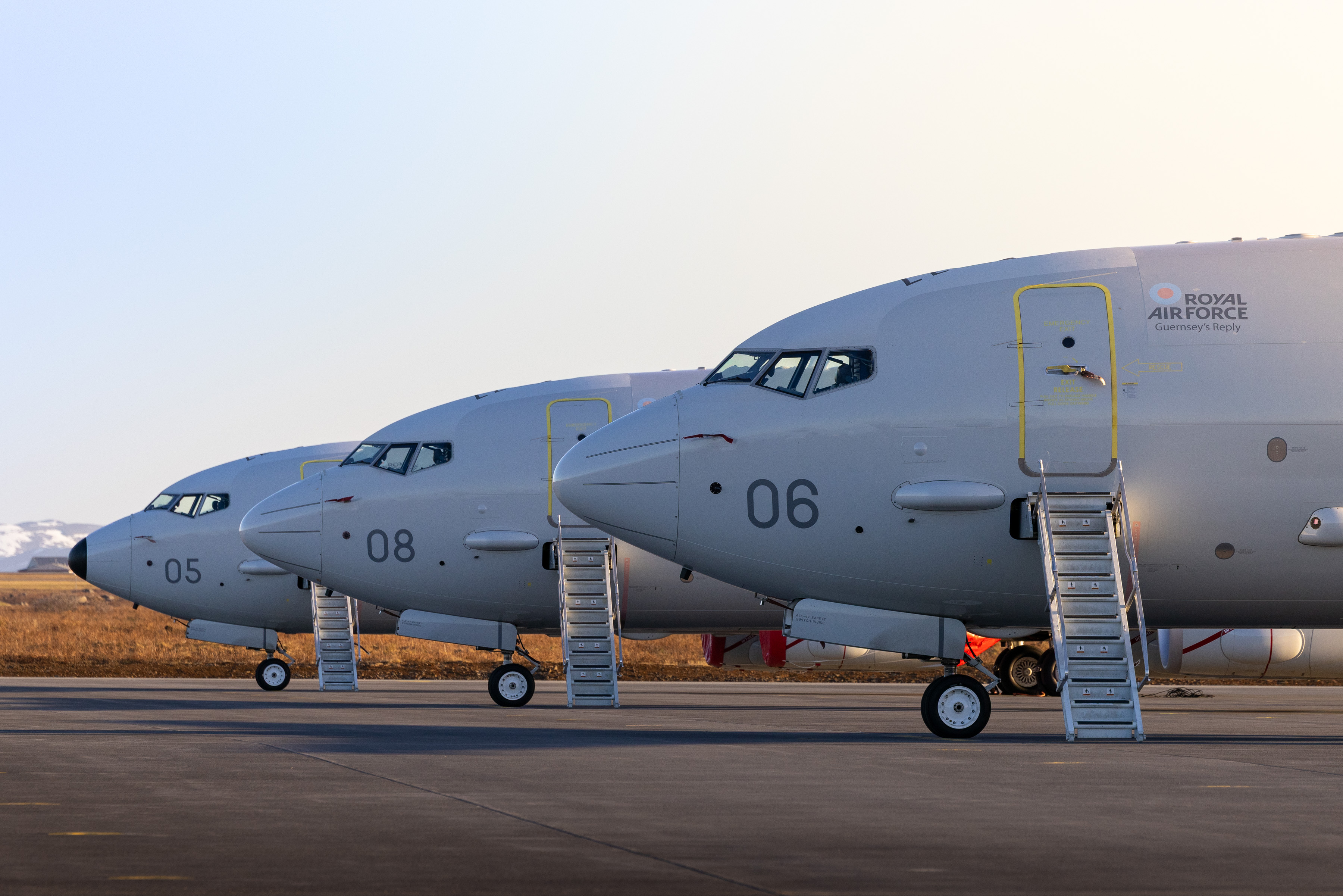 Three RAF Poseidons parked alongside one another on a runway.