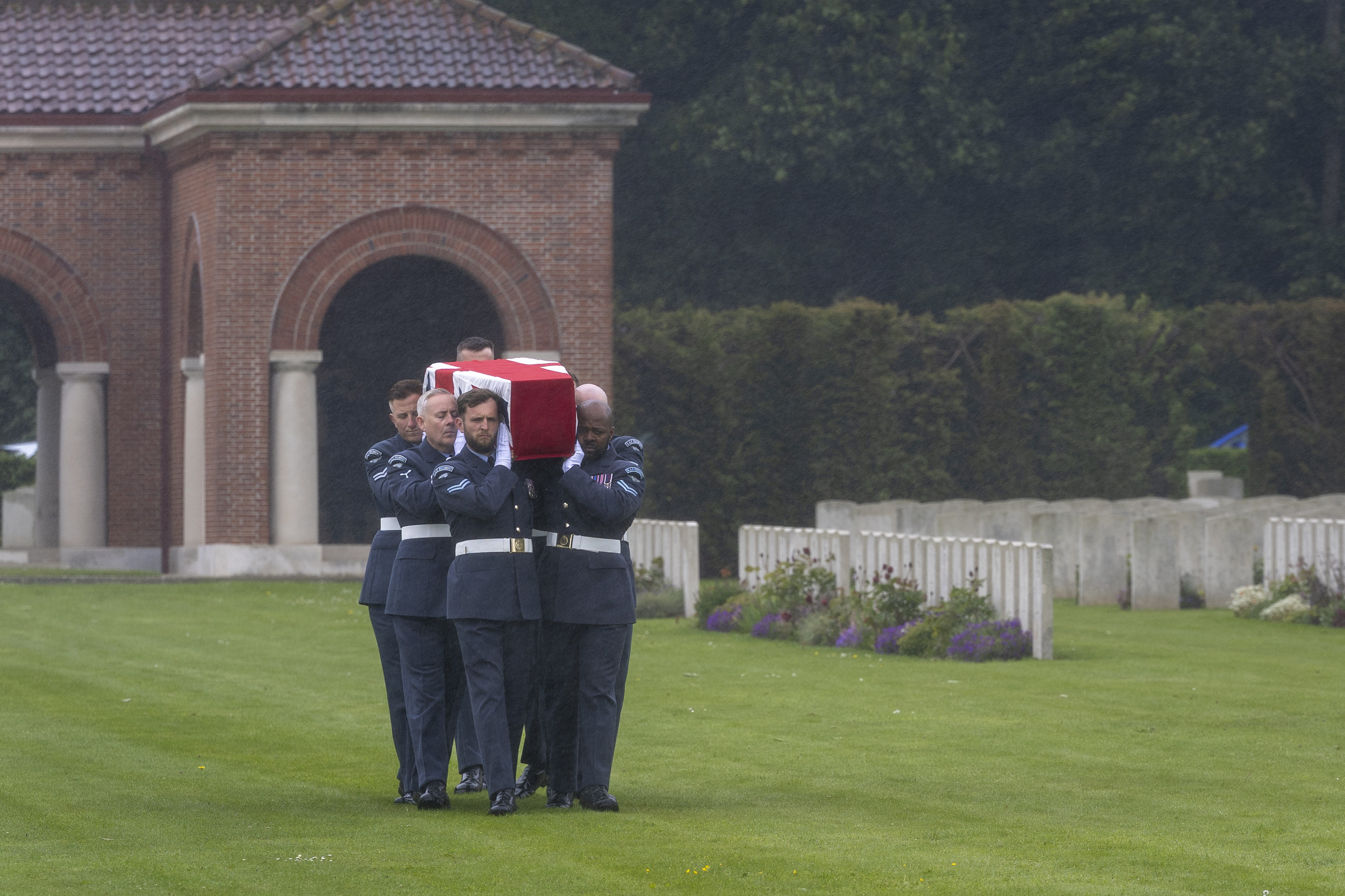 Bearers carry Sqn Ldr Fidler's coffin to his grave