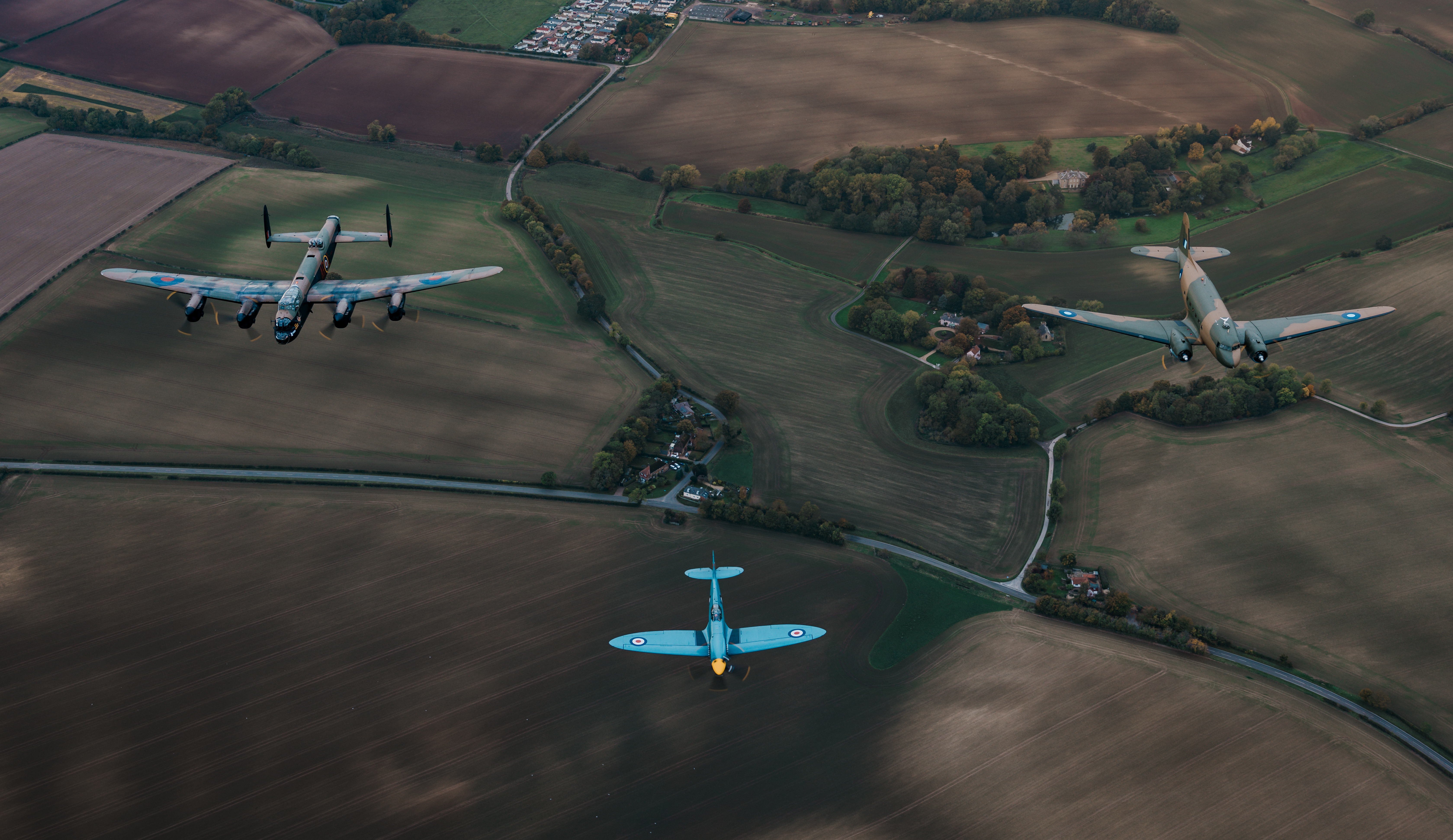 Battle of Britain Memorial Flight aircrafts Dakota, Spitfire and Lancaster flying in formation.
