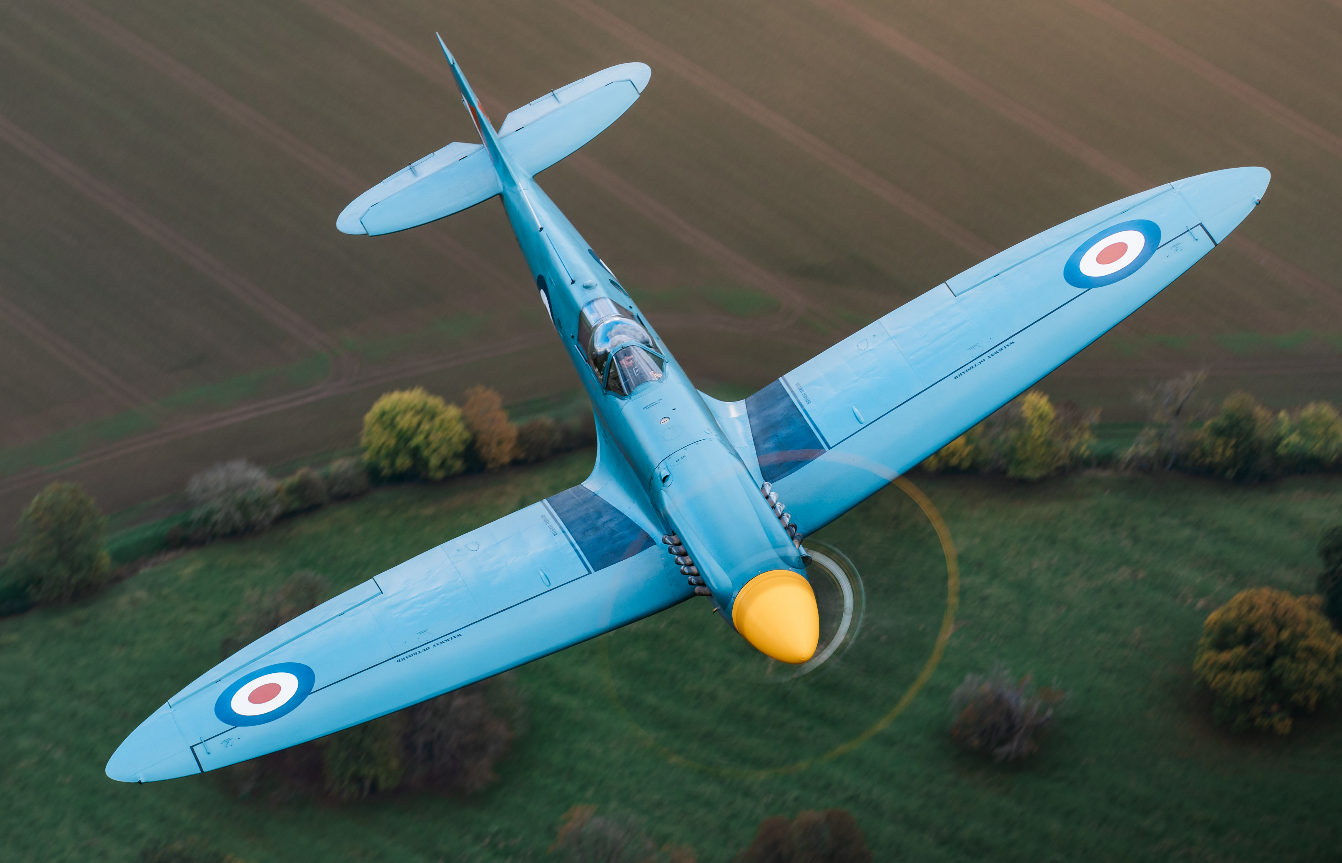 Spitfire painted in blue flying beneath the RAF A400M.