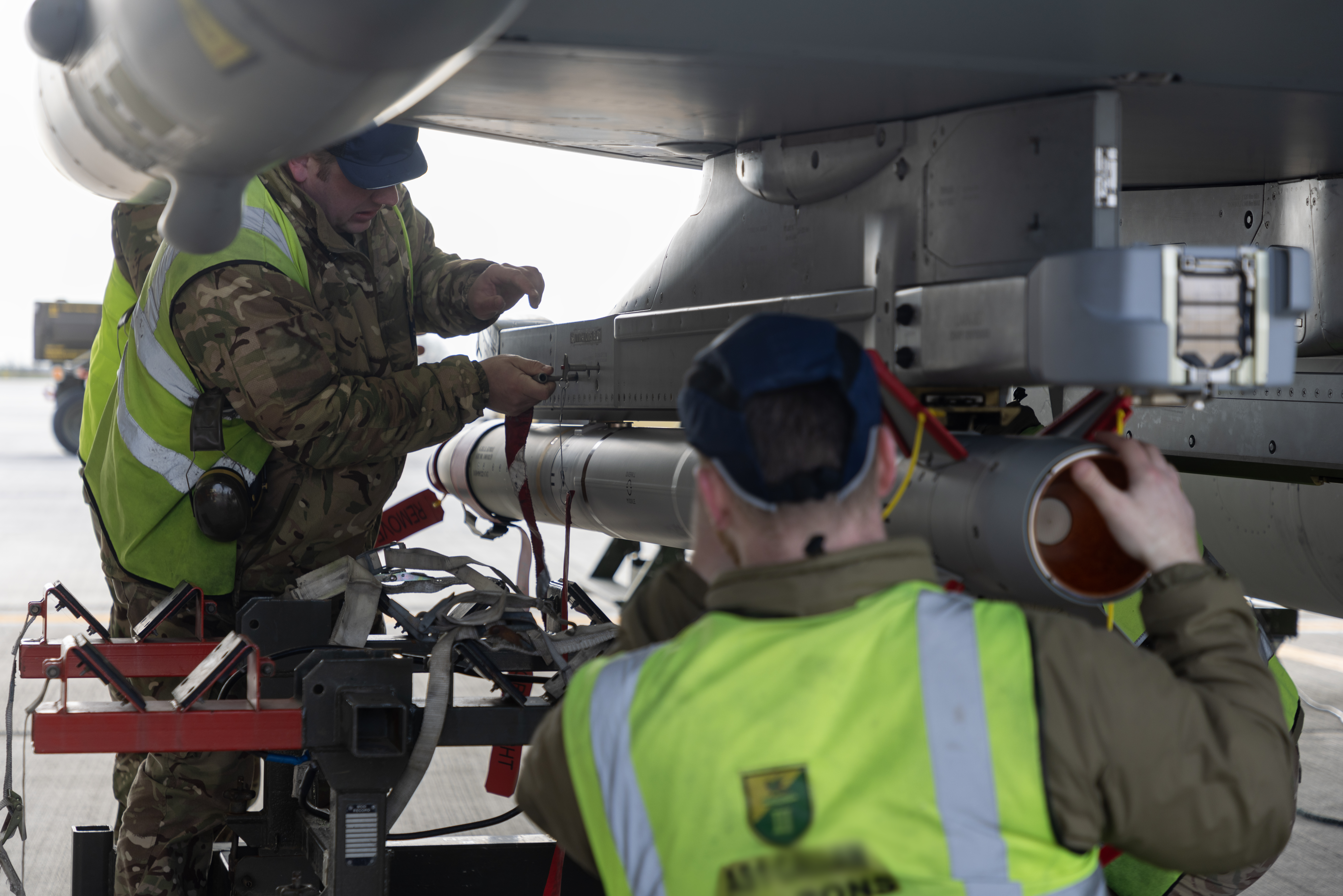 RAF ground crew fitting an Advanced Short Range Air-to-Air Missile (ASRAAM) to the underside of a Typhoon.