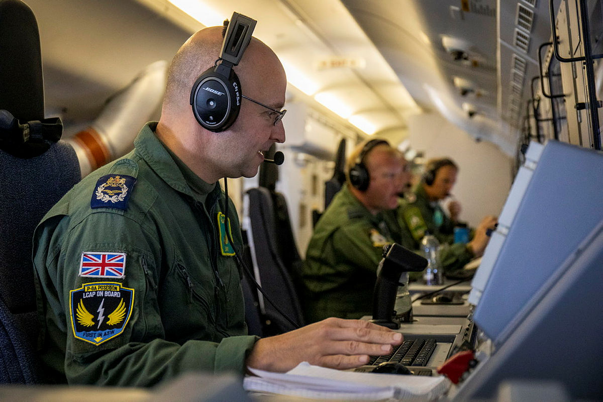 The crew of an RAF Poseidon hard at work detecting submarine threats whilst positioned at their workstations on board the aircraft.