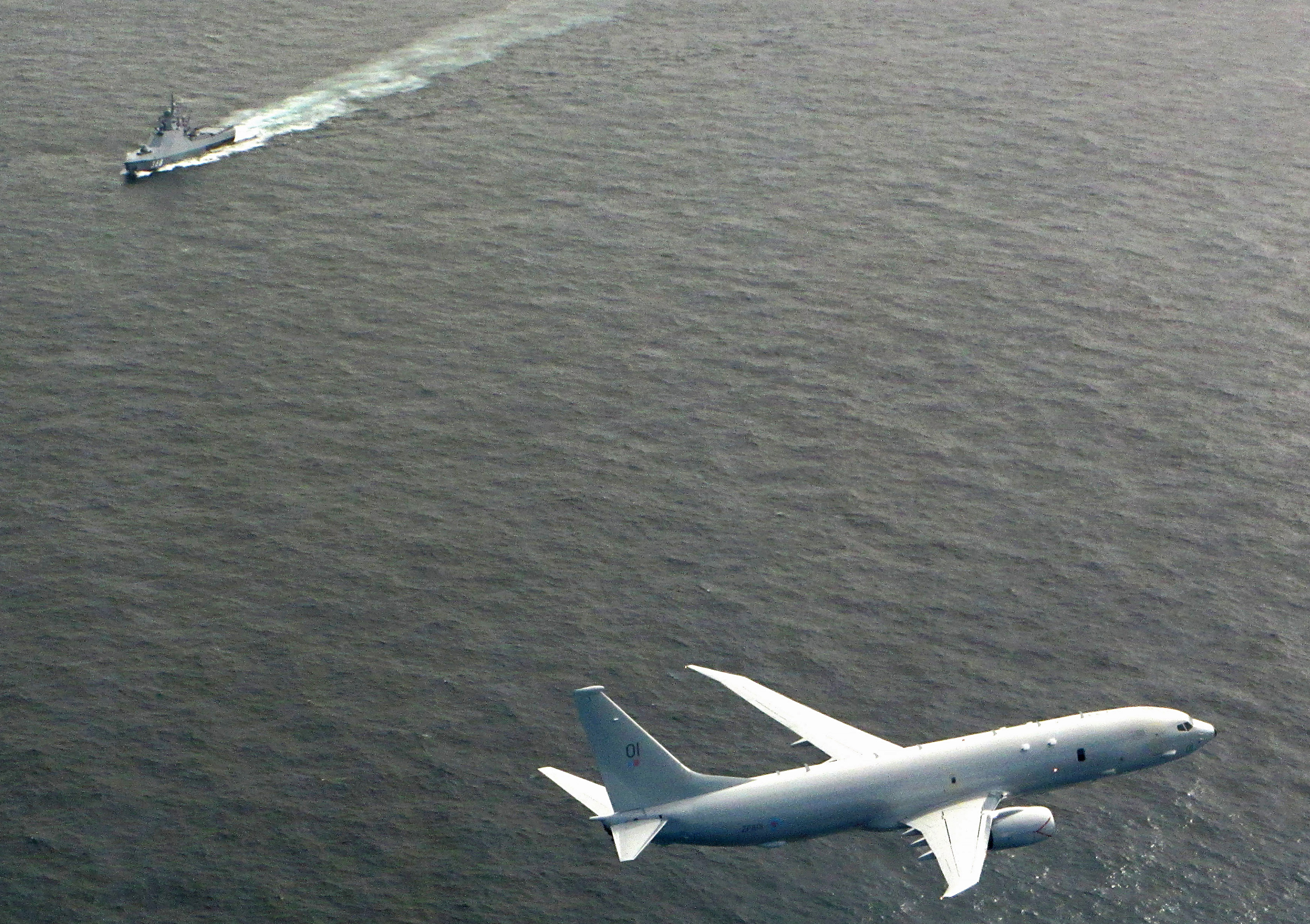 Poseidon in flight over grey waters in the foreground, with a ship visible on the water in the background.
