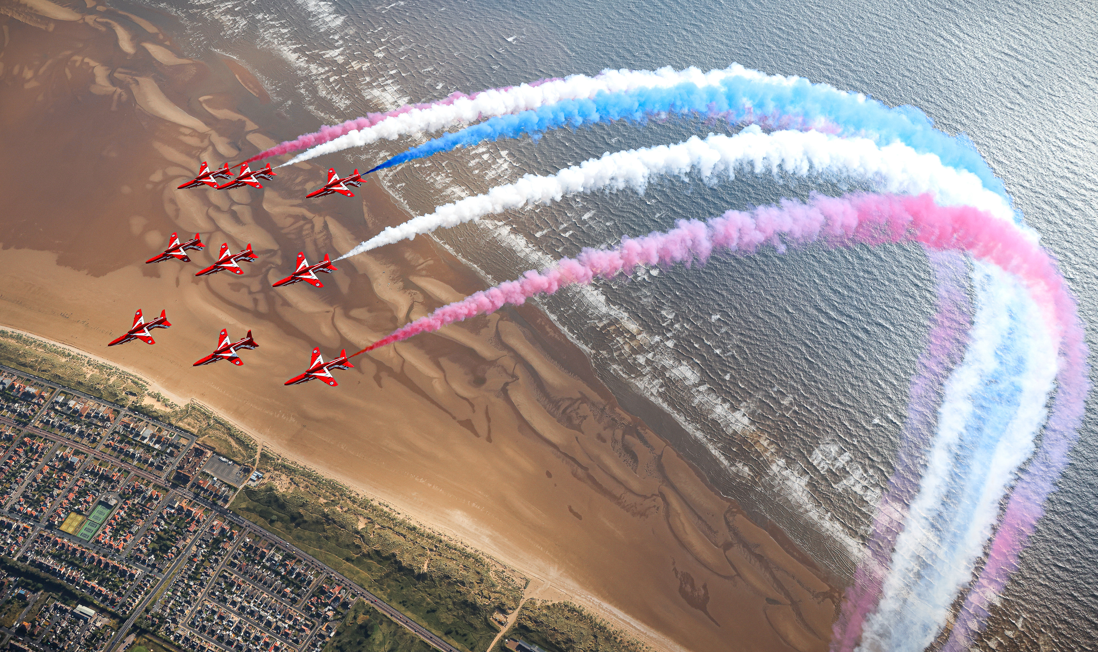 Red Arrows in formation with red, white, blue smoke trails.