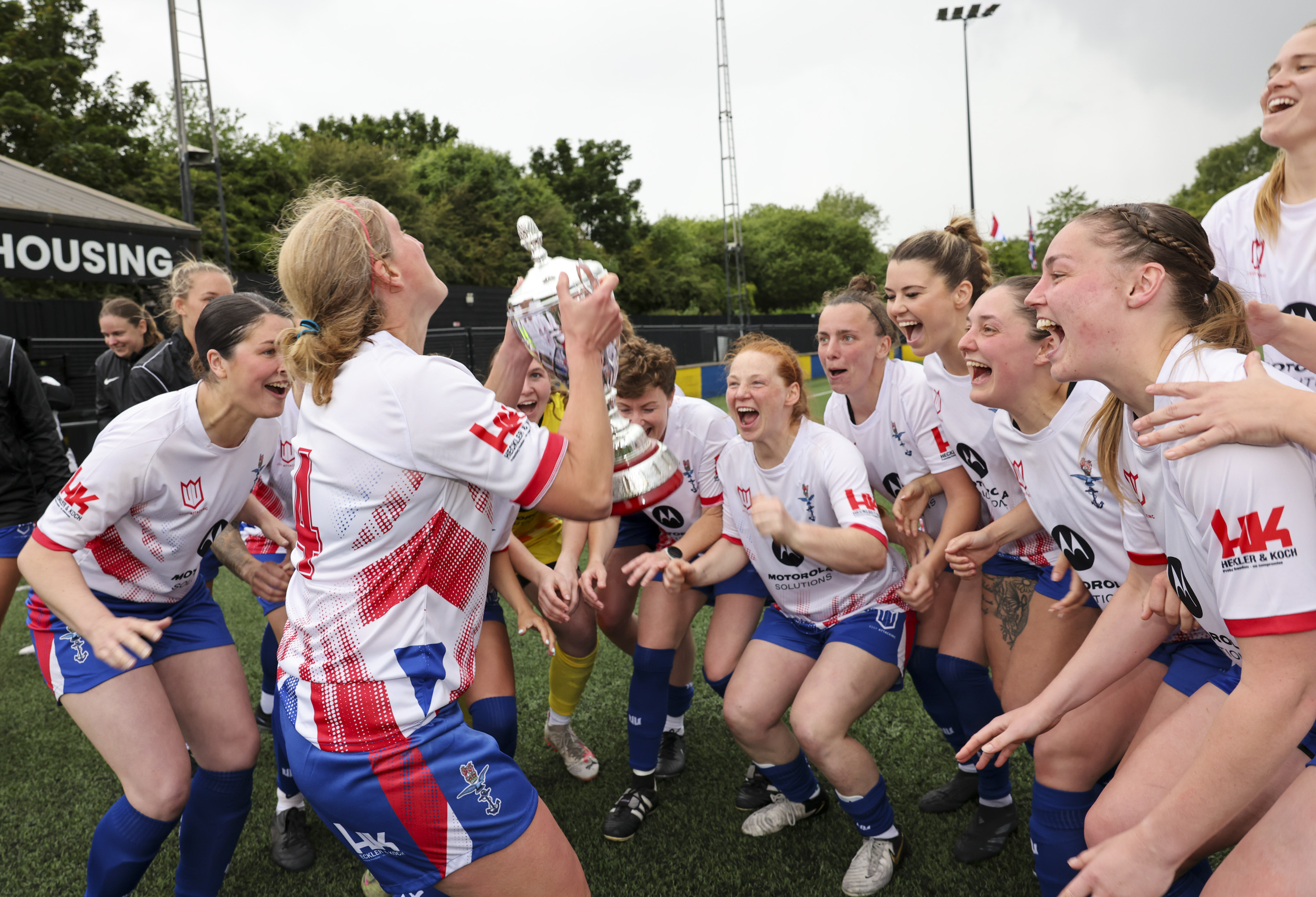 Female sports team celebrate winning the trophy.