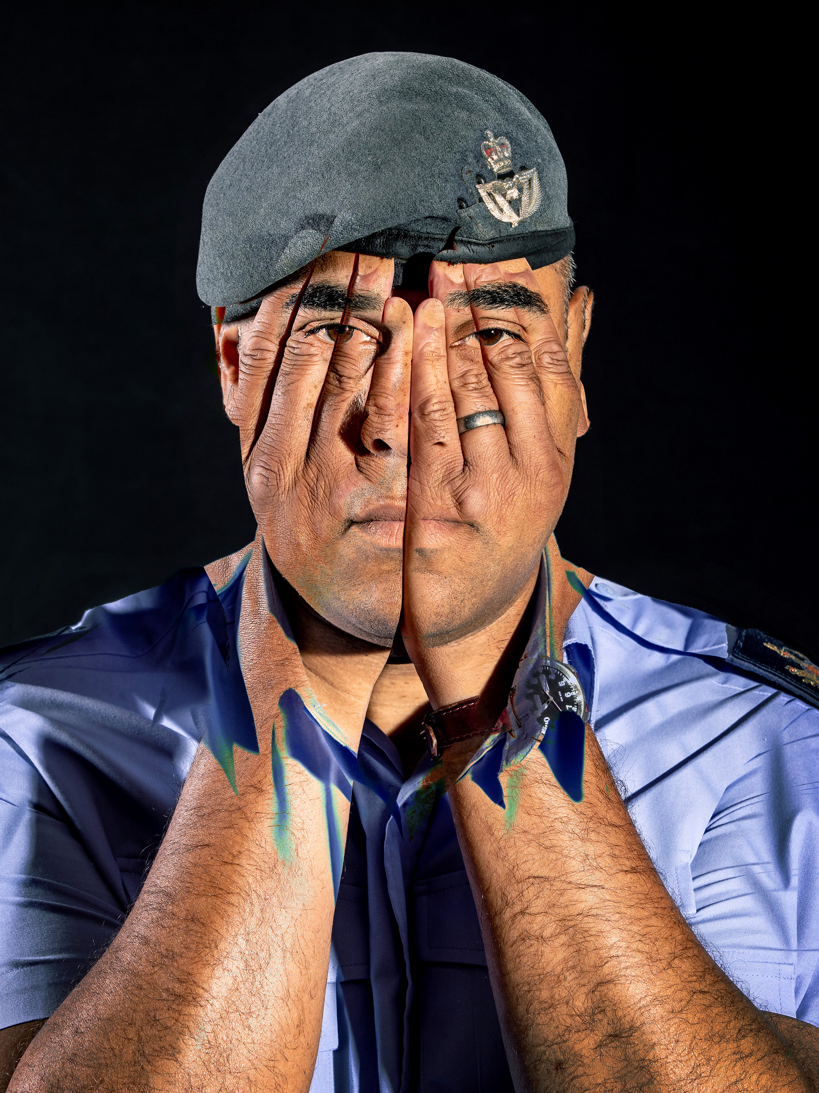 Edited image of personnel with hands over his face.