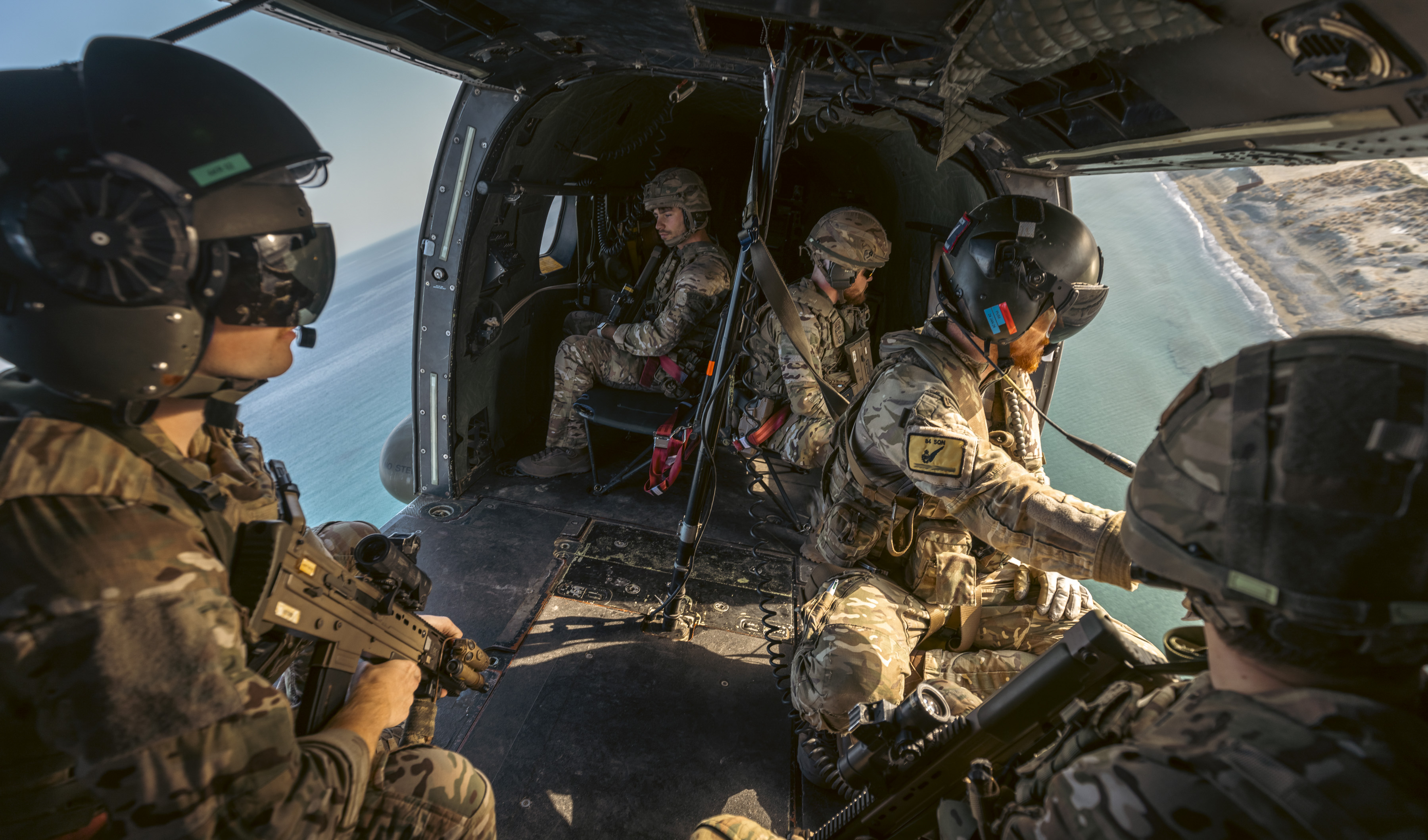 Personnel in Chinook with the doors open looking out.