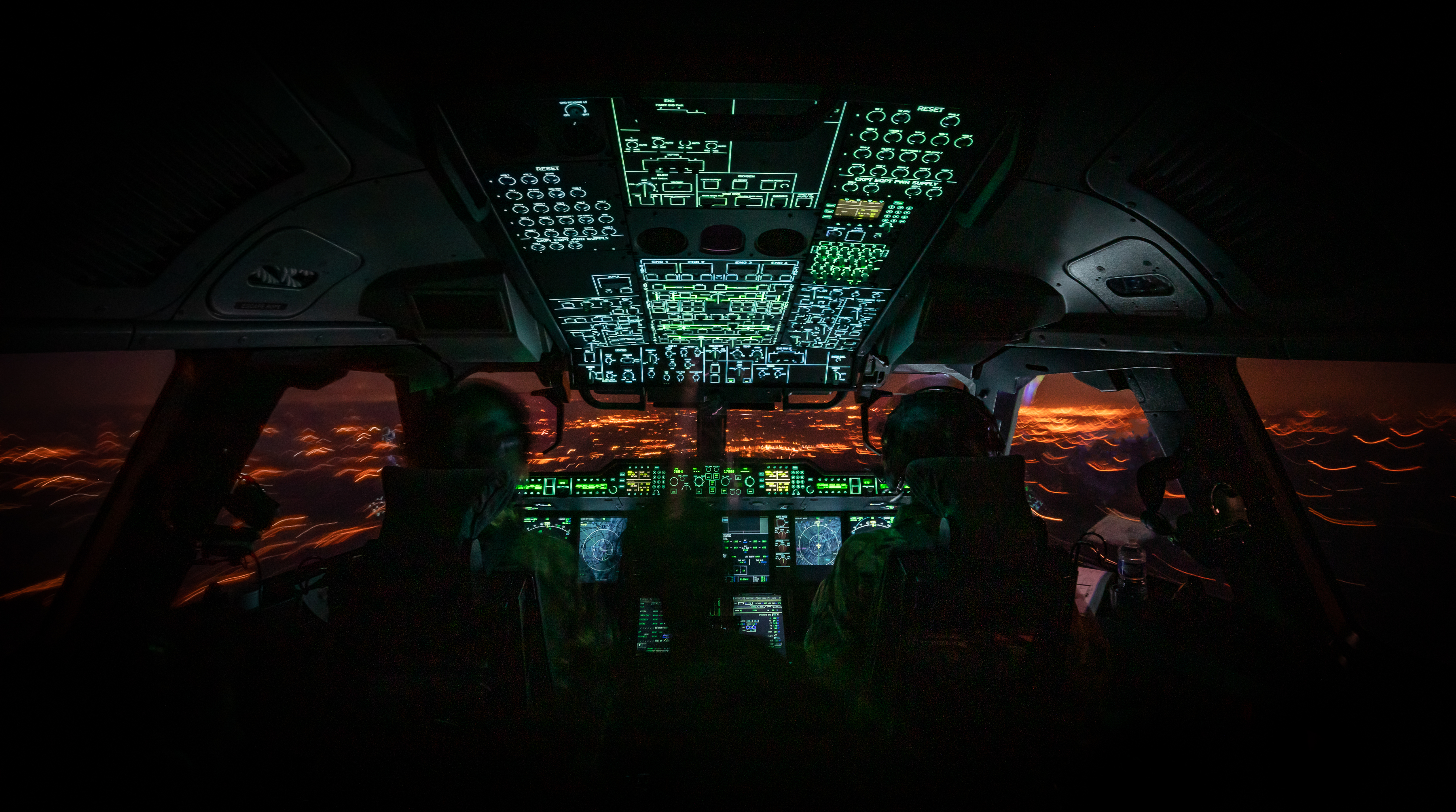 night time view of pilots flying in cockpit