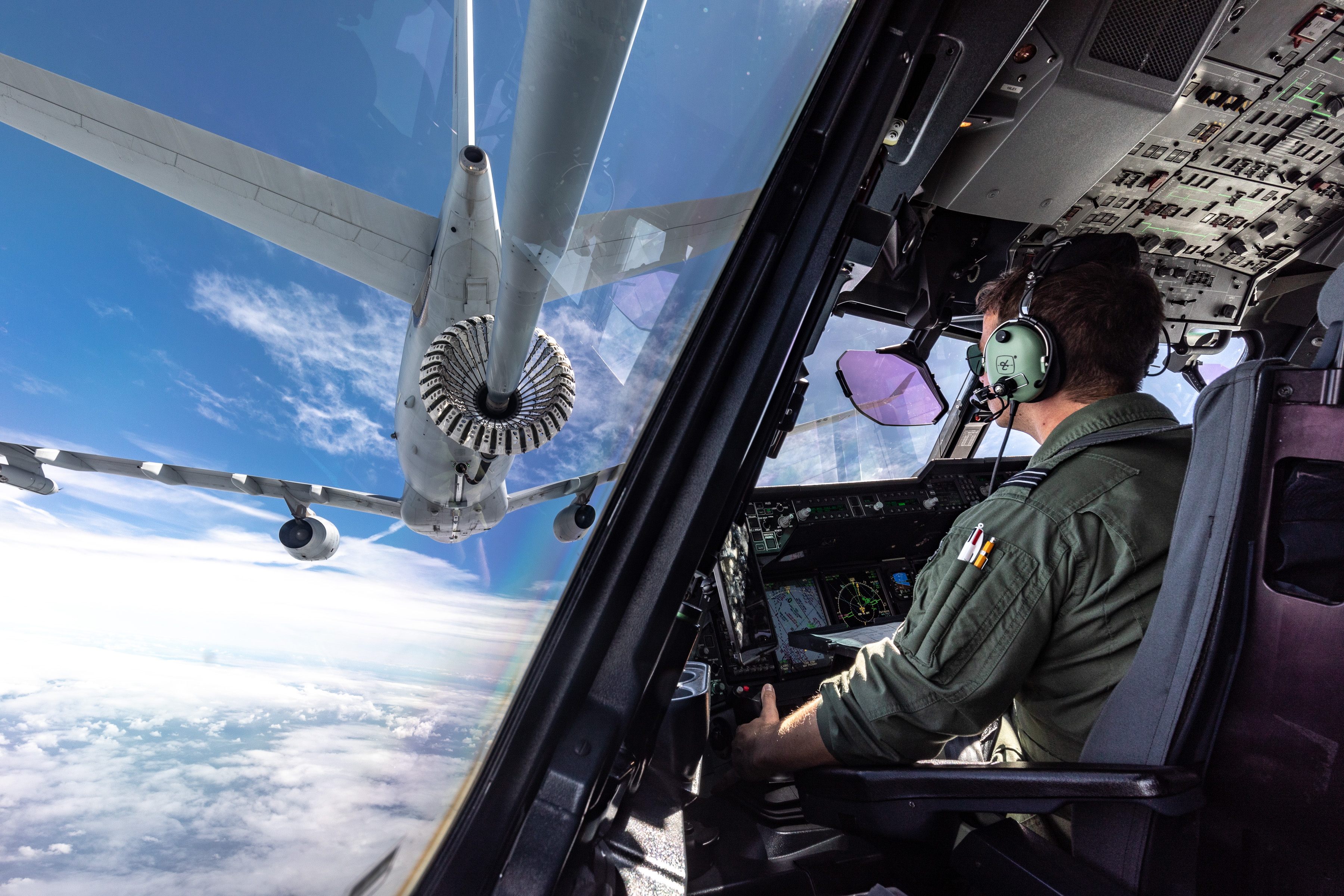 air-to-air refuelling, view from inside the aircraft seeing the pilots and the recieving plane