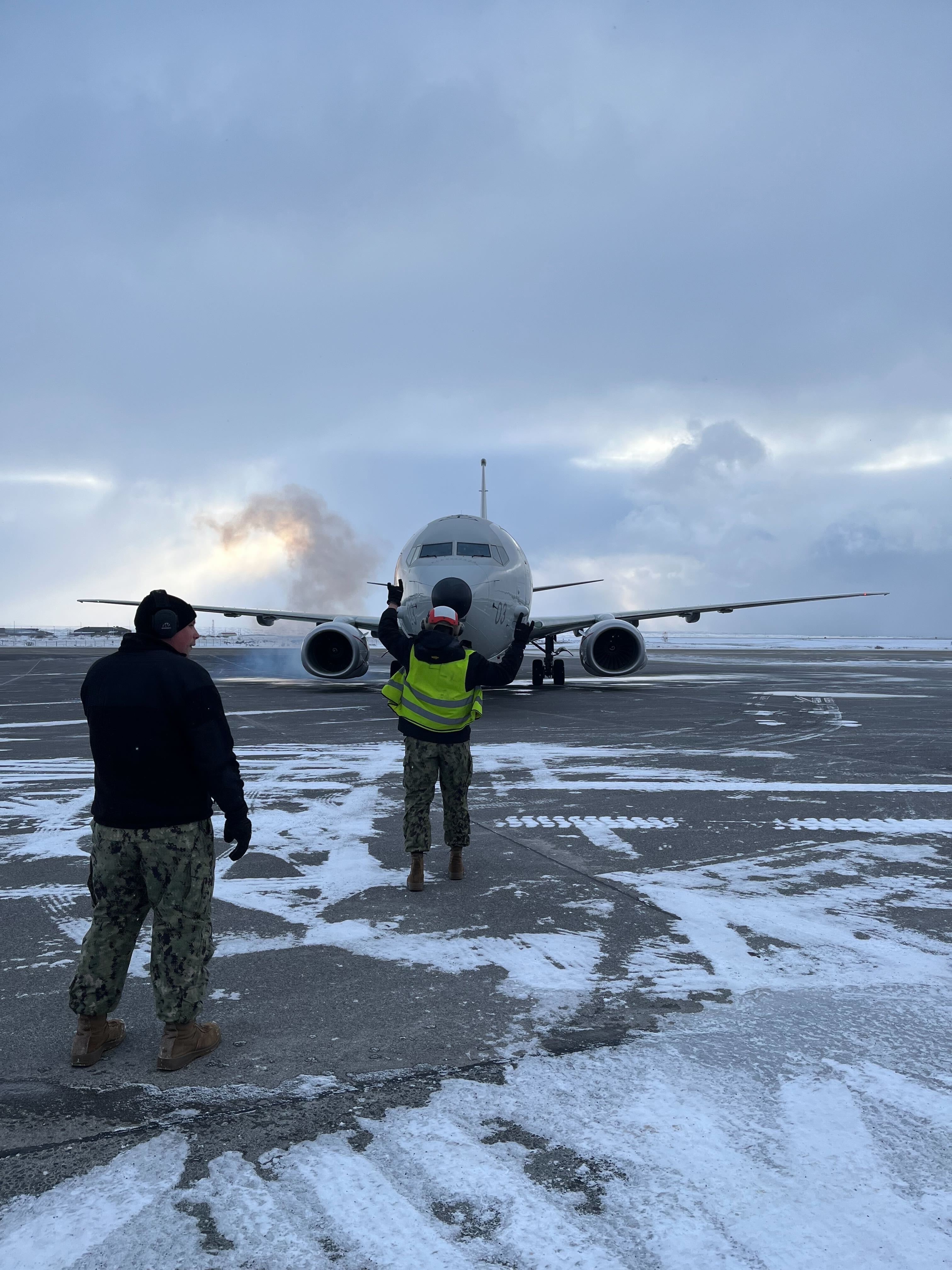 Poseidon on the ground face on. A serviceperson directing it in the forefront.