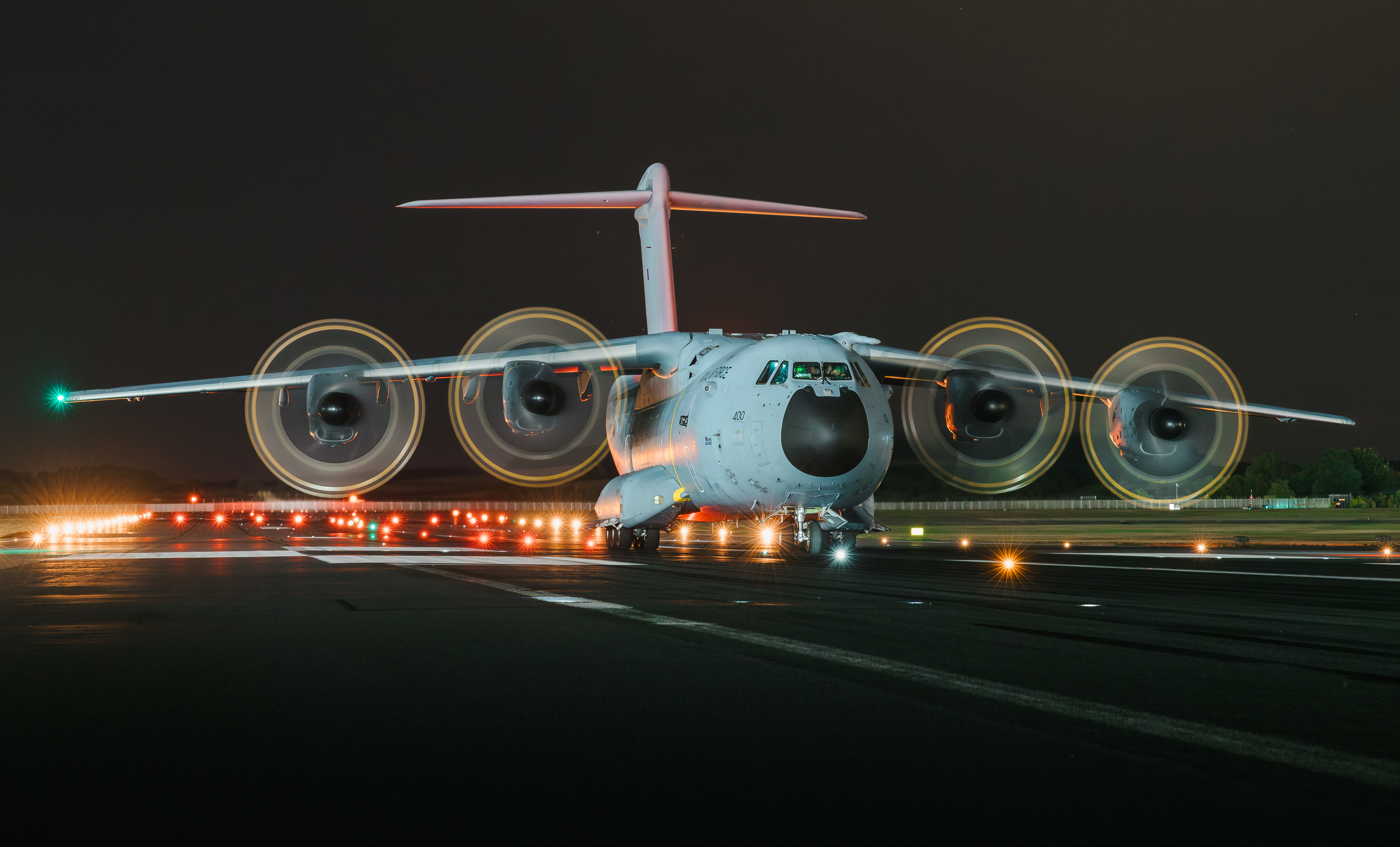 An RAF Atlas preparing for takeoff along a runway at night.
