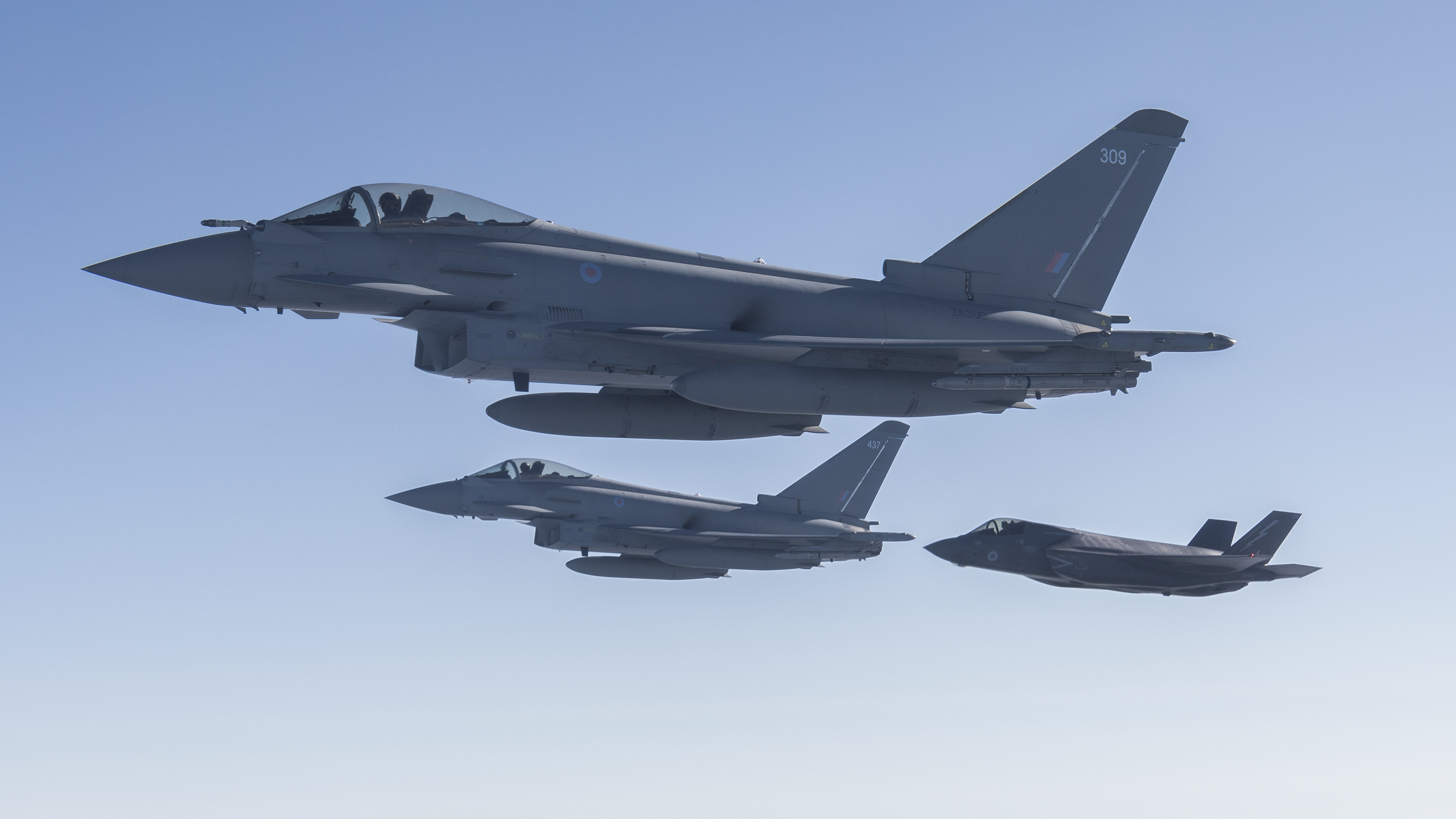 A imagem mostra dois RAF Typhoons voando com um RAF F-35.